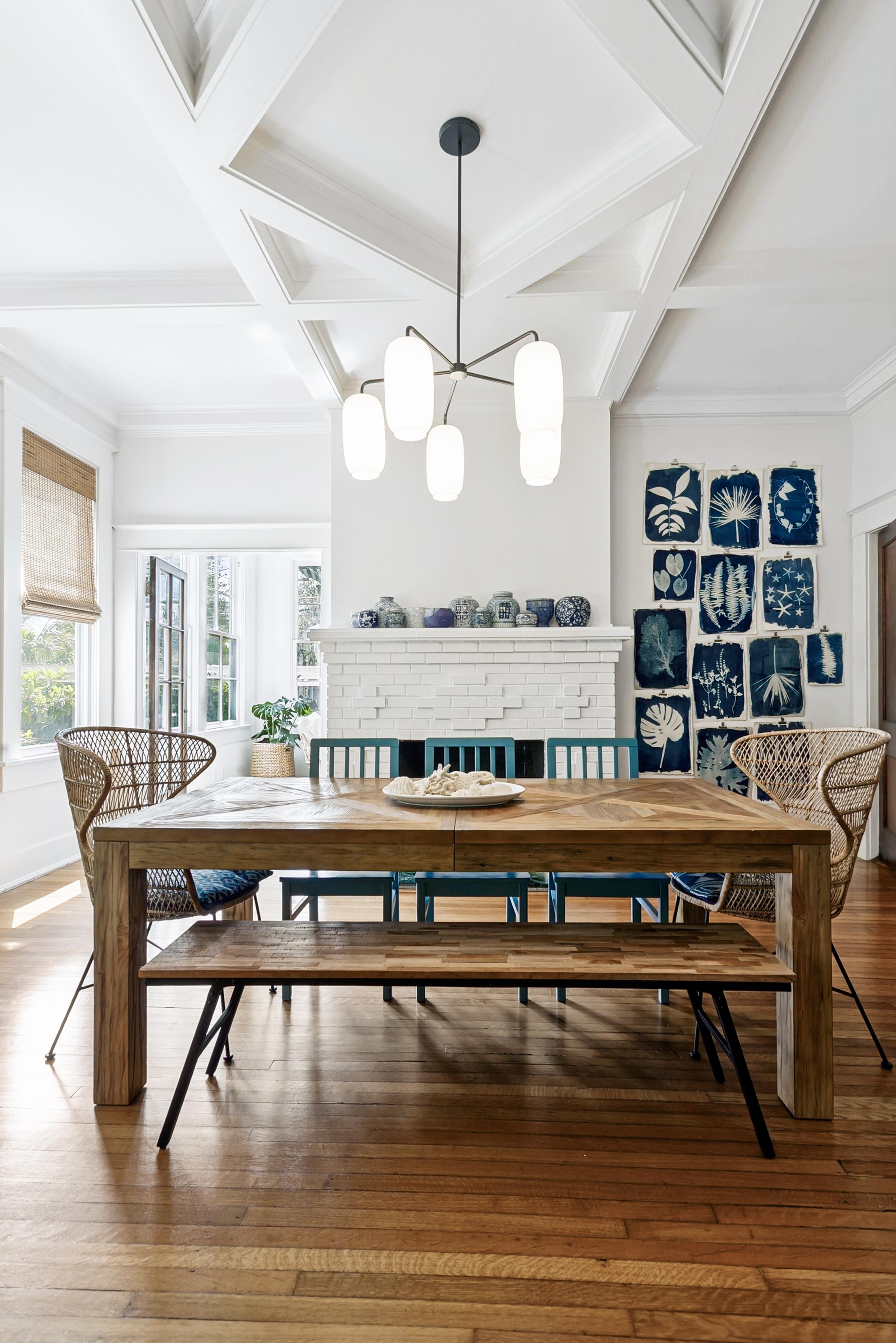 Elegant dining room with coffered vaulted ceiling, rustic wood table, and gallery wall of botanical prints in San Antonio, Texas