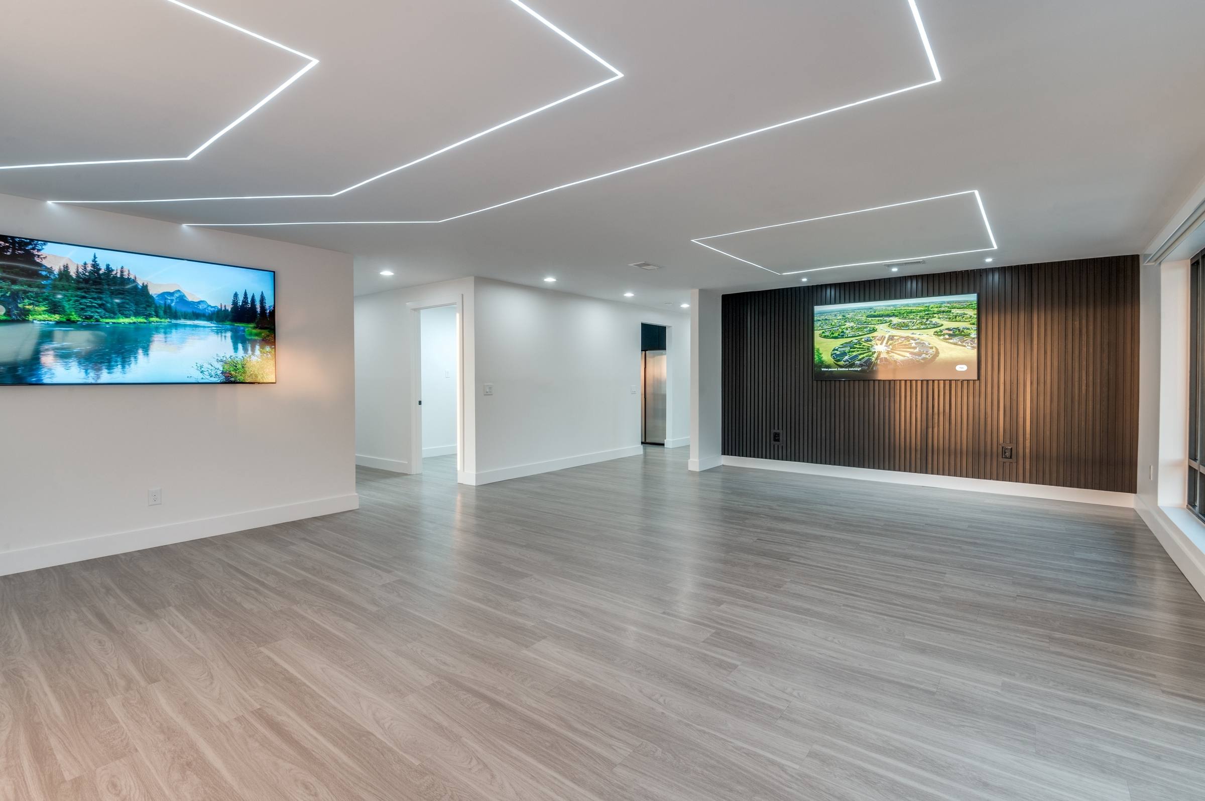 Empty modern office lobby with geometric ceiling lights and wood slat accent wall before virtual staging in Dallas, Texas