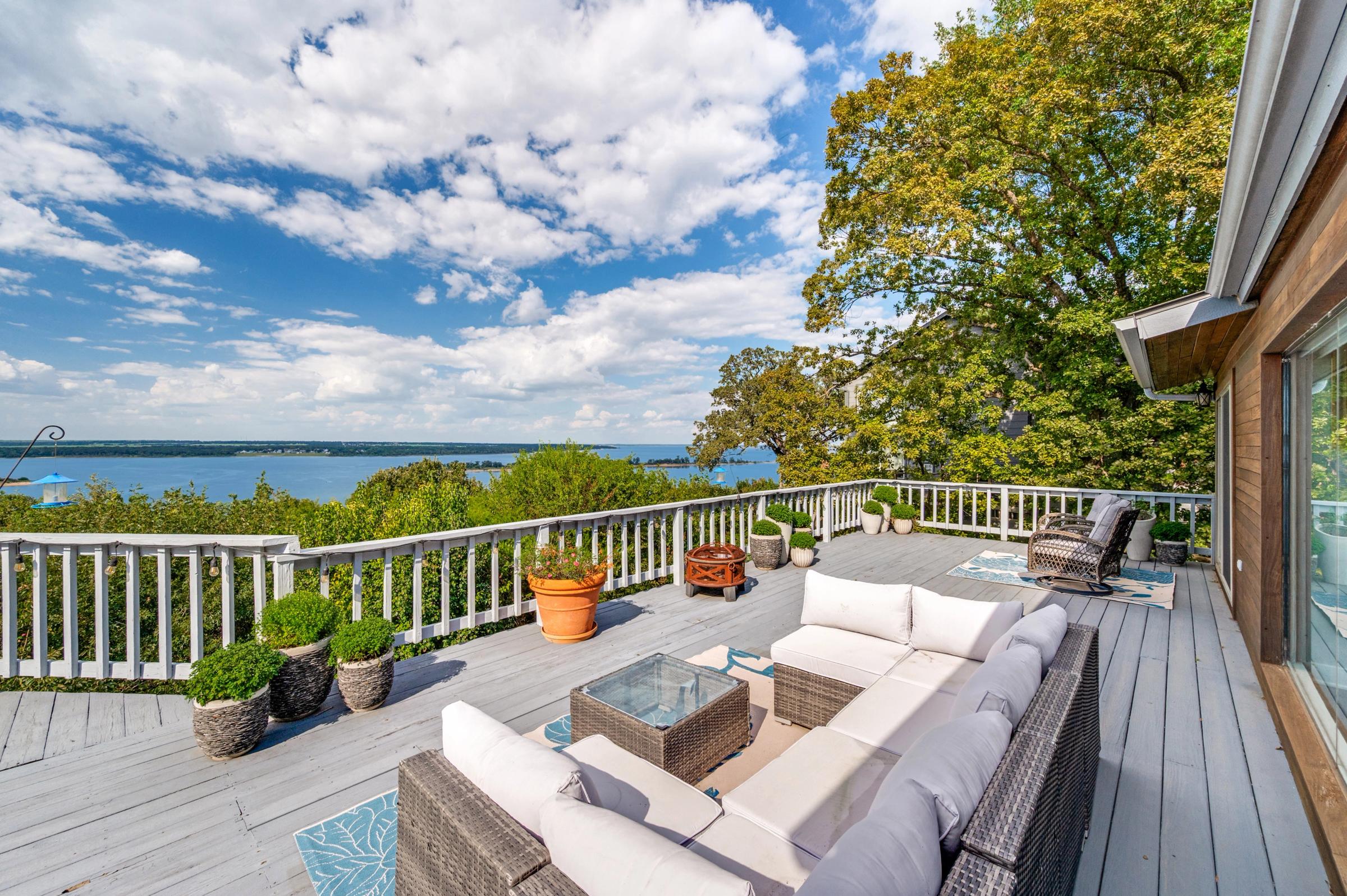 Spacious outdoor deck with wicker furniture and panoramic Lake Texoma views under blue skies in Pottsboro, Texas