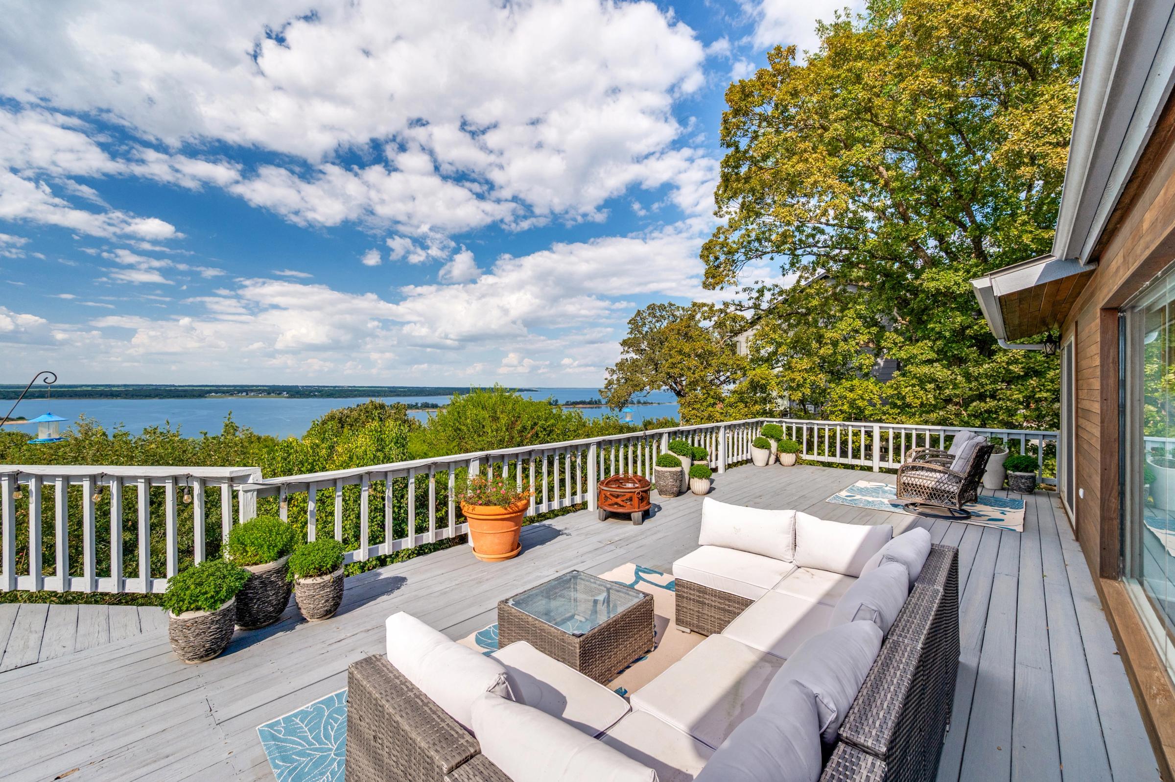 Spacious outdoor deck with wicker furniture and panoramic Lake Texoma views under blue skies in Pottsboro, Texas