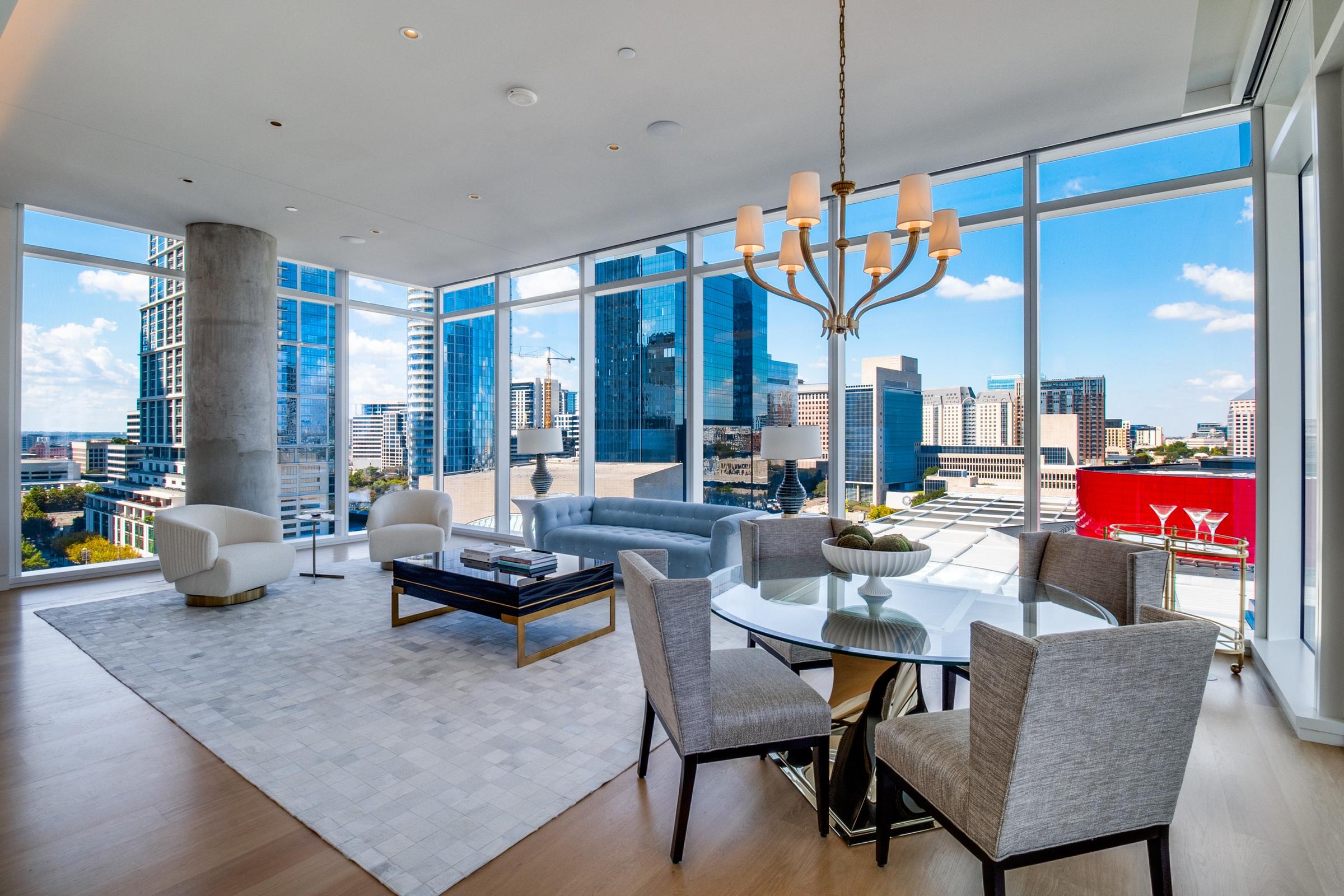 Modern high-rise living room with floor-to-ceiling windows overlooking the Dallas skyline, contemporary furnishings in Dallas, Texas