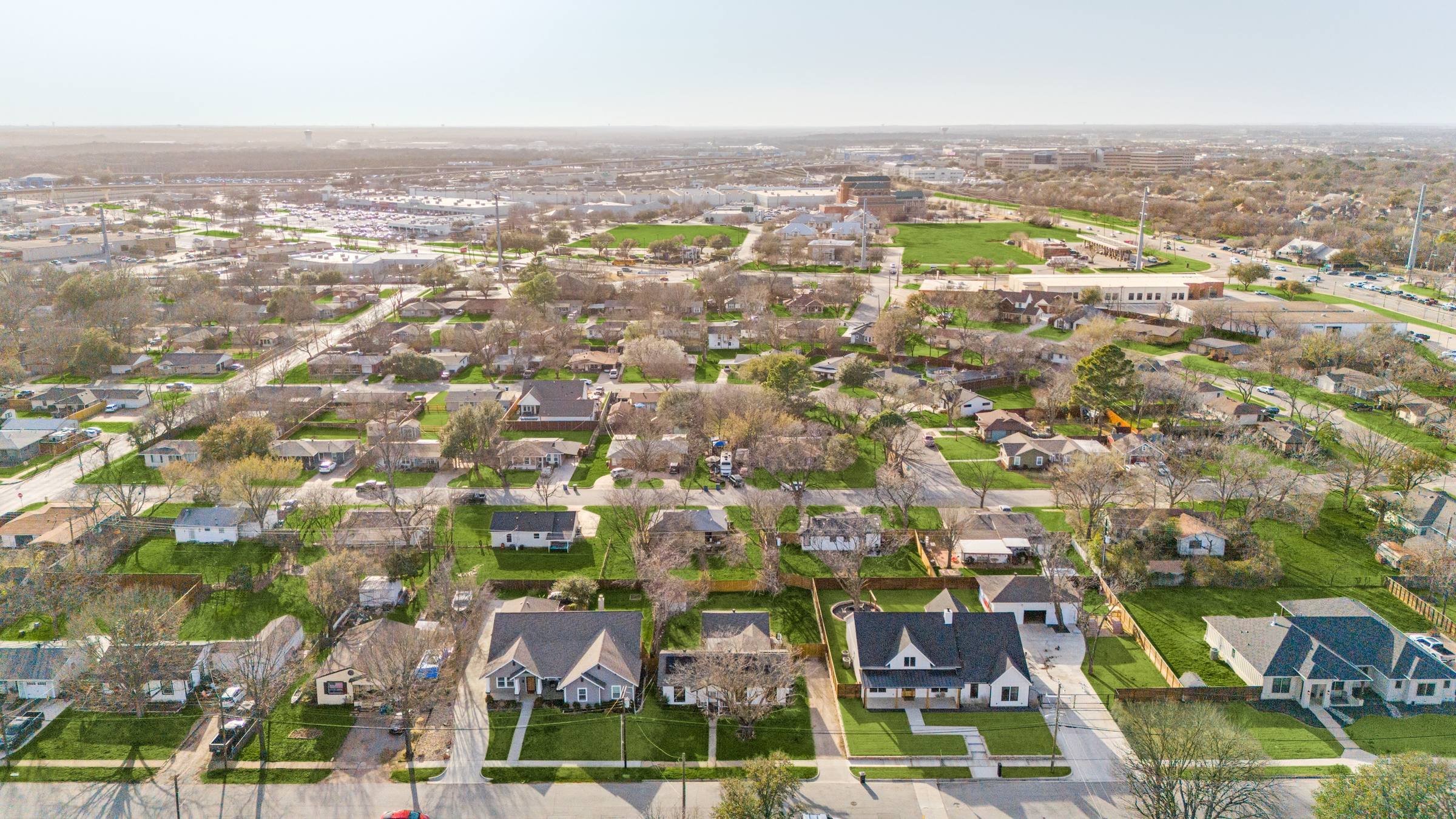 Aerial drone photography with green grass enhancement showing a residential neighborhood with lush lawns in Grapevine, Texas