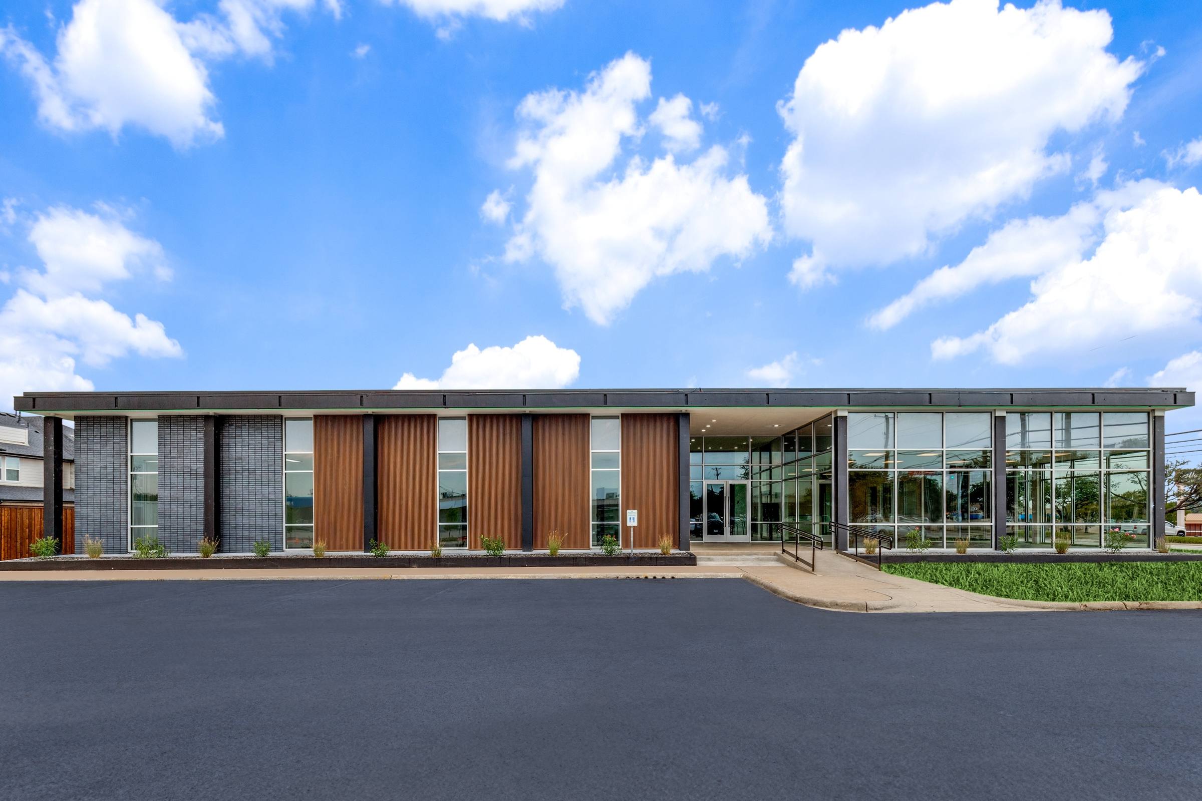 Modern commercial building exterior with fresh asphalt parking lot after virtual staging enhancement in Farmers Branch, Texas