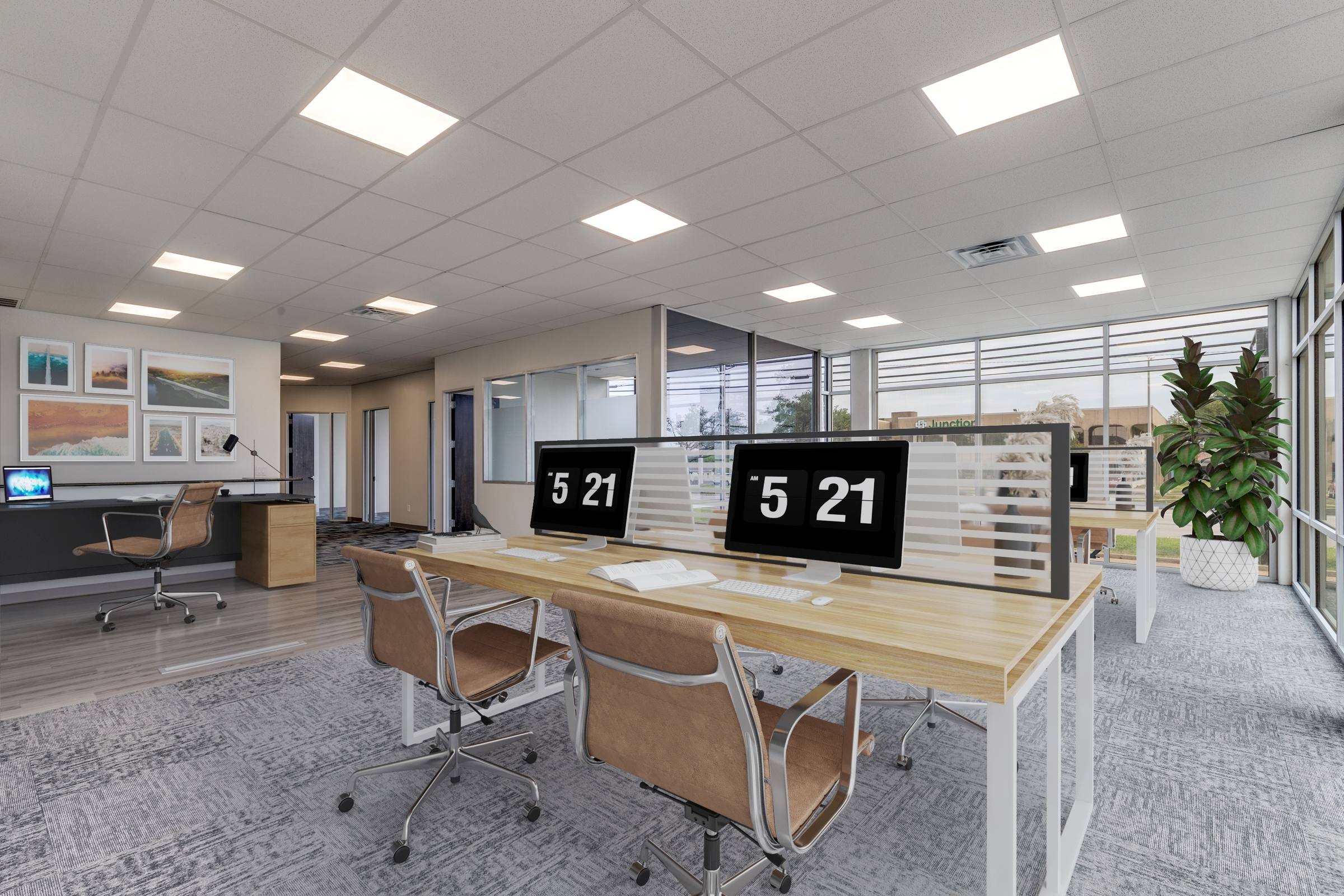 Virtually staged commercial office with desks, monitors, chairs, gallery wall, and plant accents in Farmers Branch, Texas