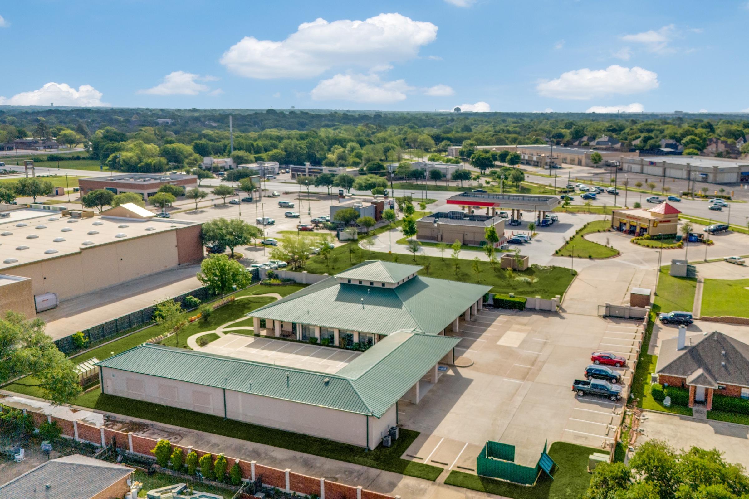 Aerial view of commercial building with distinctive green roof on Grapevine Highway in Hurst, Texas