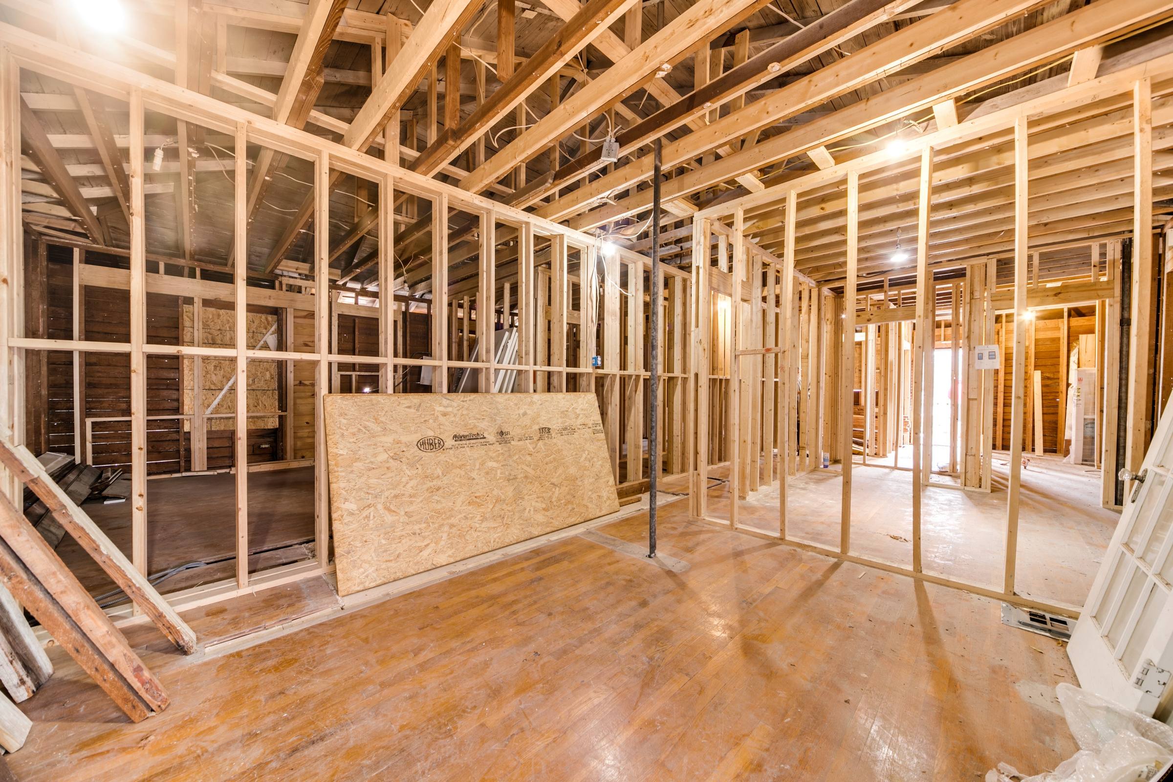 Interior wood framing of new construction home showing exposed studs and open floor plan in San Antonio, Texas
