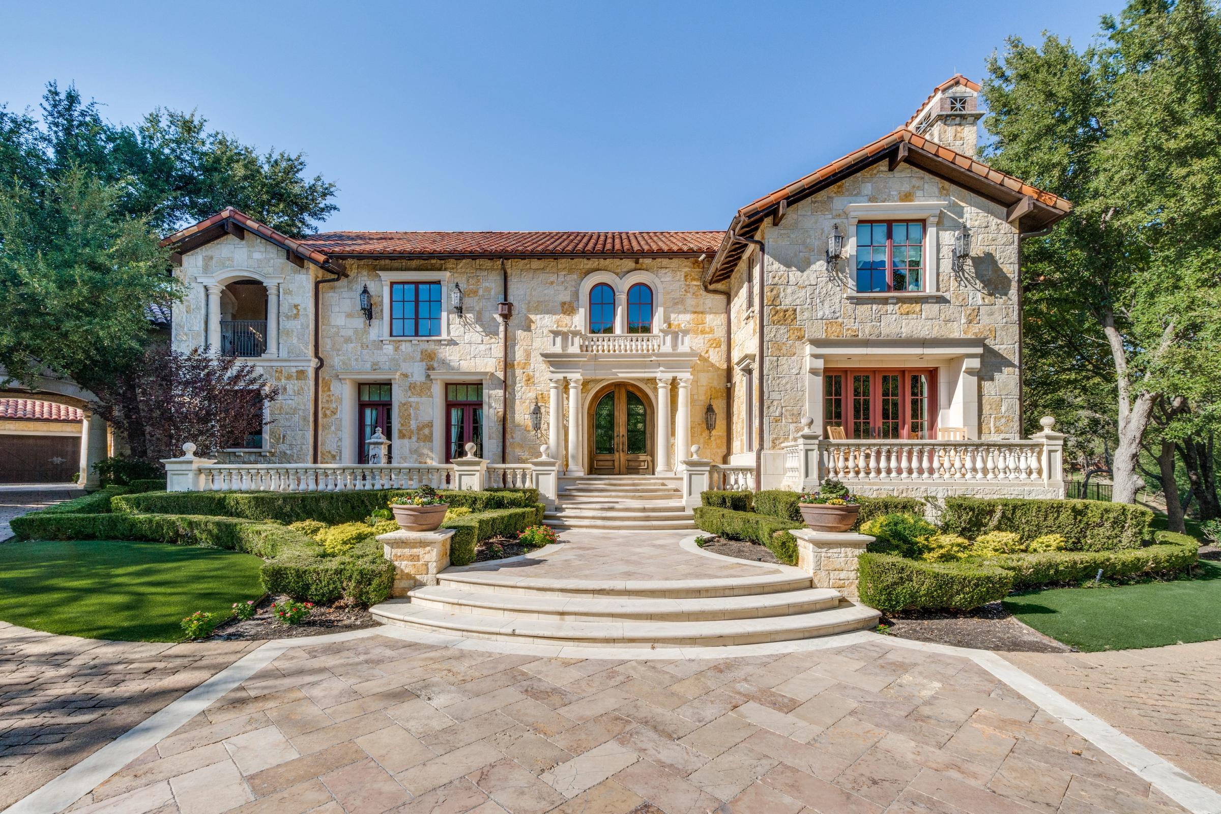 Grand Tuscan-style stone estate with clay tile roof, circular driveway, and manicured landscaping in Coppell, Texas