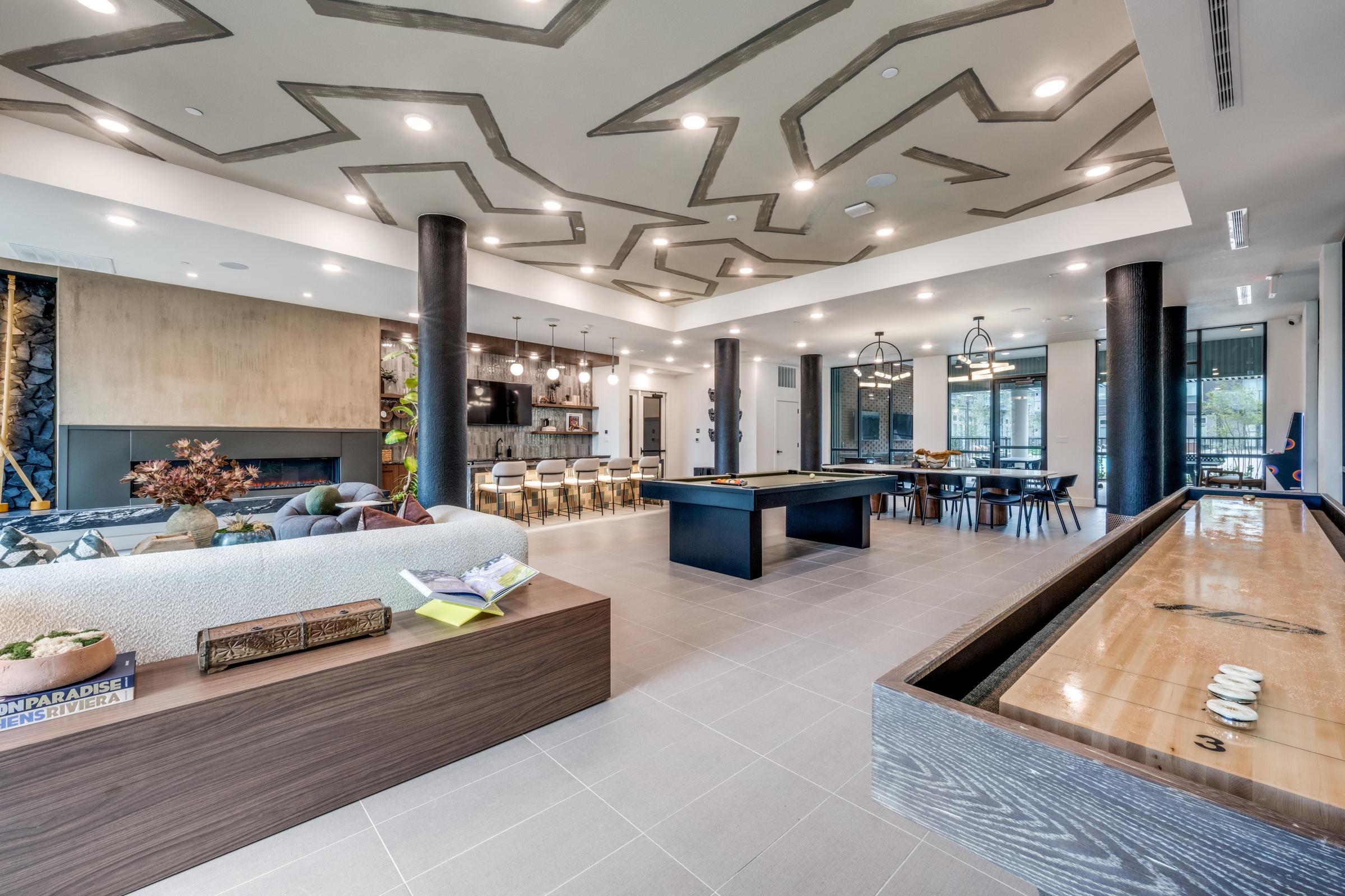 Luxury apartment clubhouse with pool table, shuffleboard, and fireplace lounge in Denton, Texas