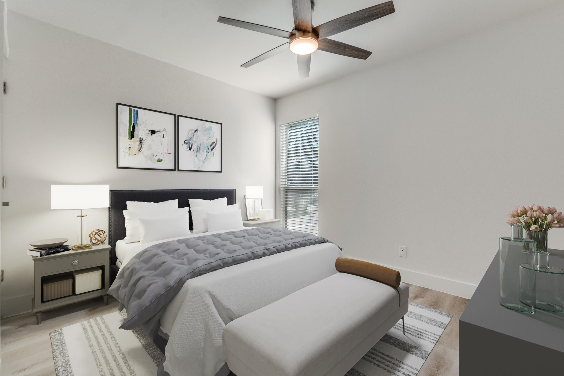 Apartment bedroom virtually staged with queen bed, gray comforter, abstract artwork, nightstands, and pink tulips in Dallas, Texas
