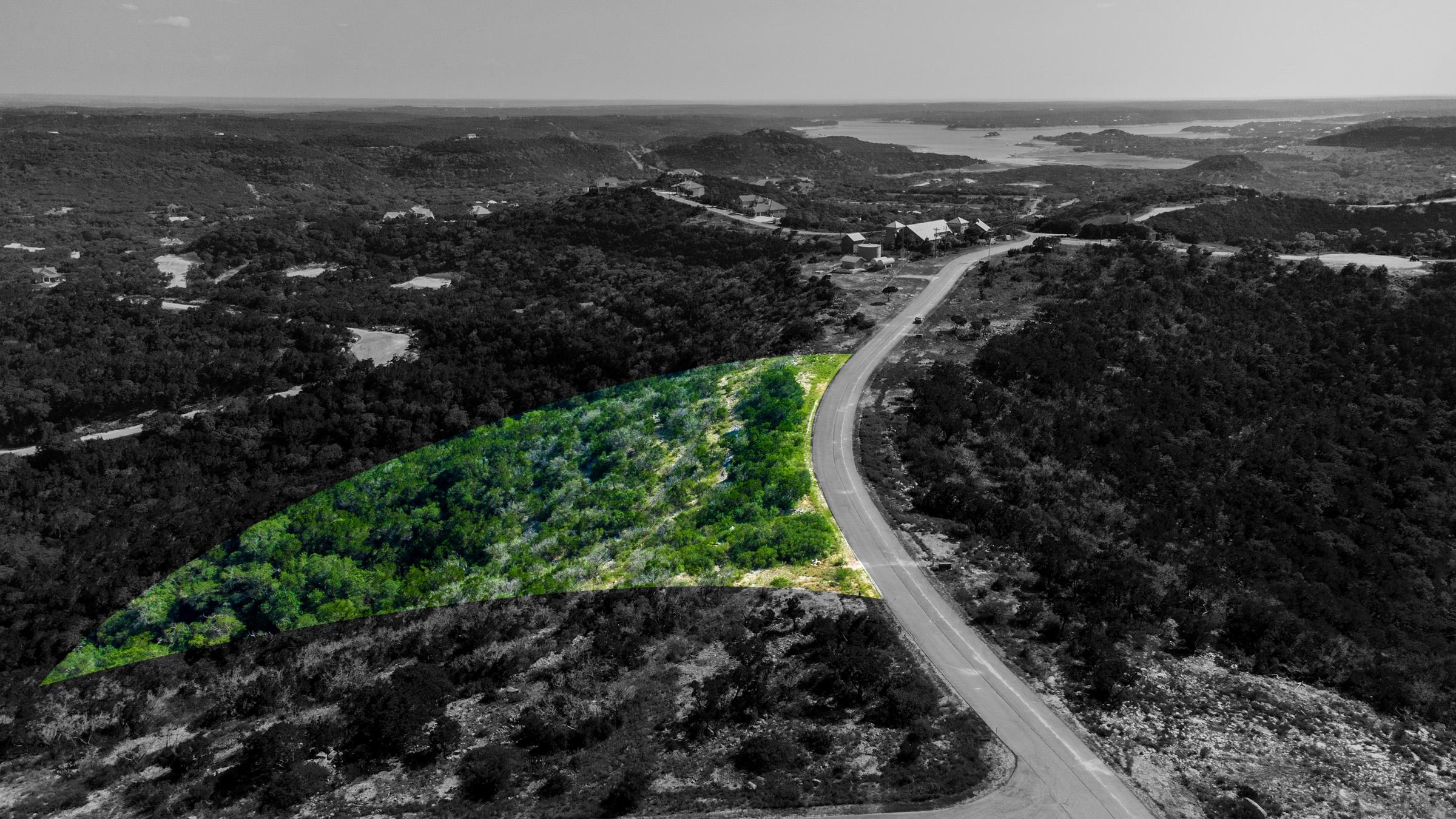 Aerial ColorPop shot highlighting a wooded lot parcel in color against a black-and-white Hill Country landscape at Dancing Bear Ranch, Texas.
