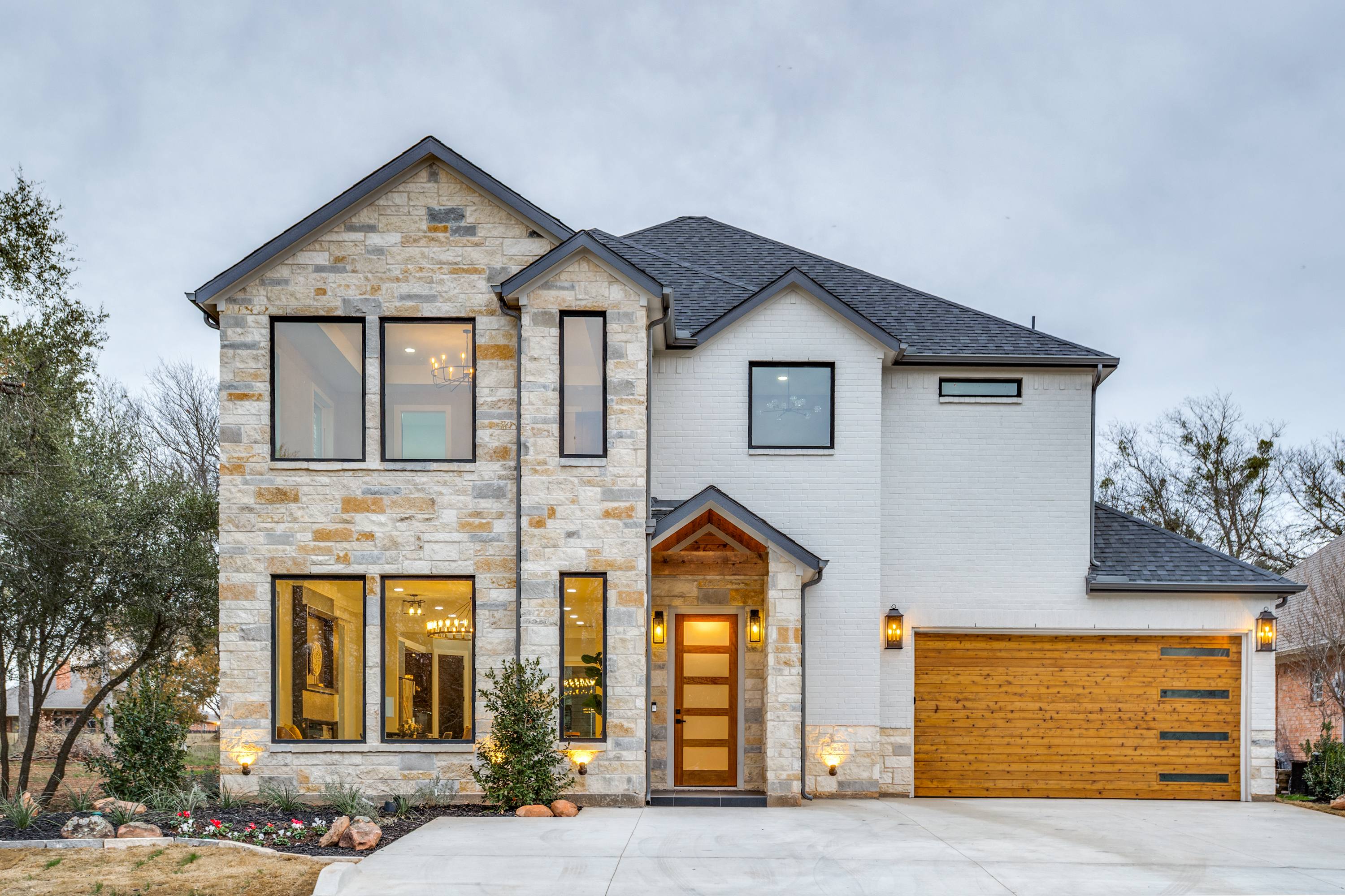 Front exterior of a new-construction stone and brick two-story home in Whitney, TX