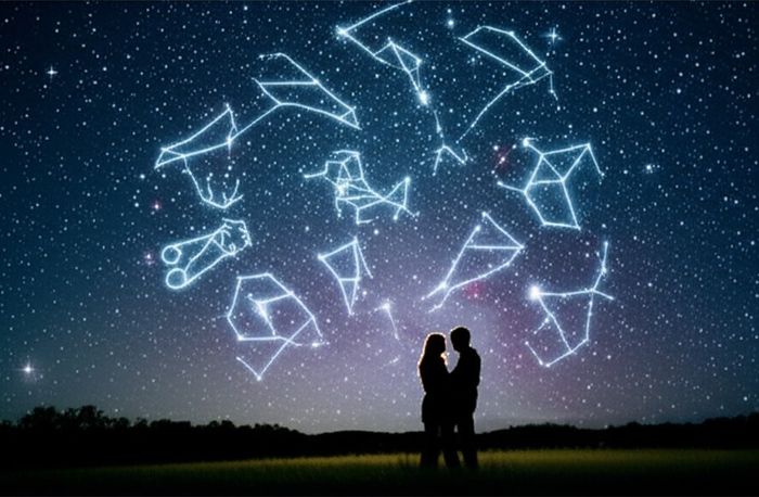 A couple under a starry sky with astrological constellations and zodiac signs glowing faintly