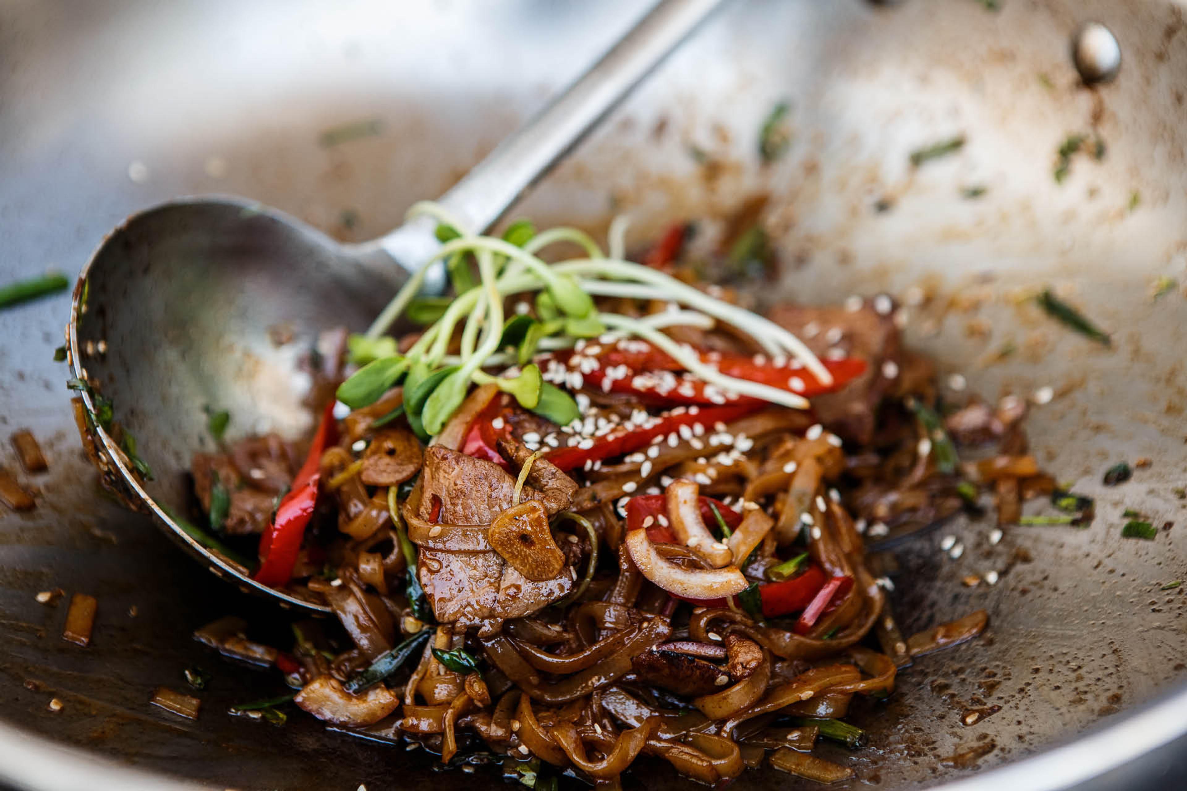 Grönsaker och kött som tillagas i en wokpanna