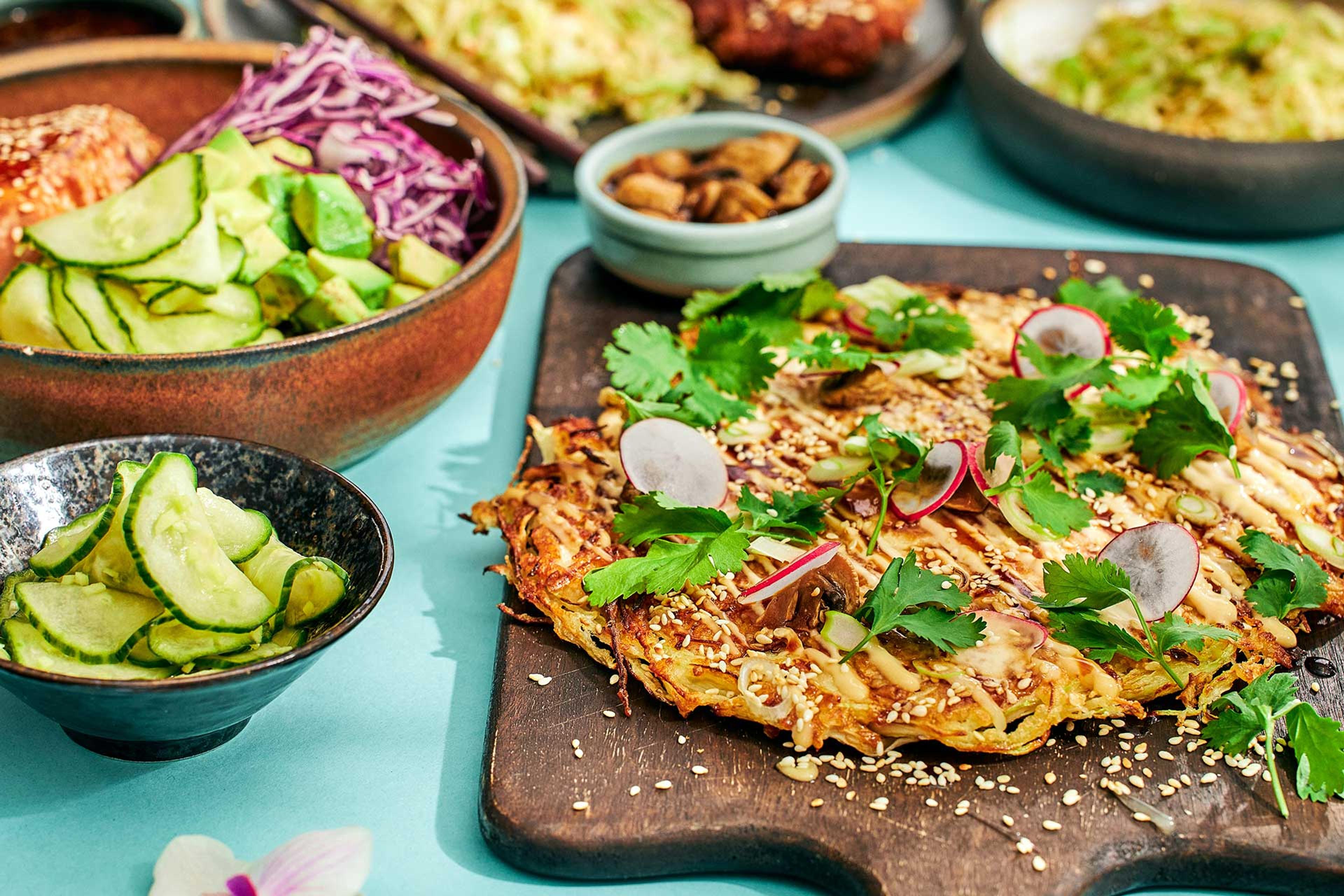 Okonomiyaki, eller japansk kålpannkaka, med topping av rädisor, koriander och sesamfrön.