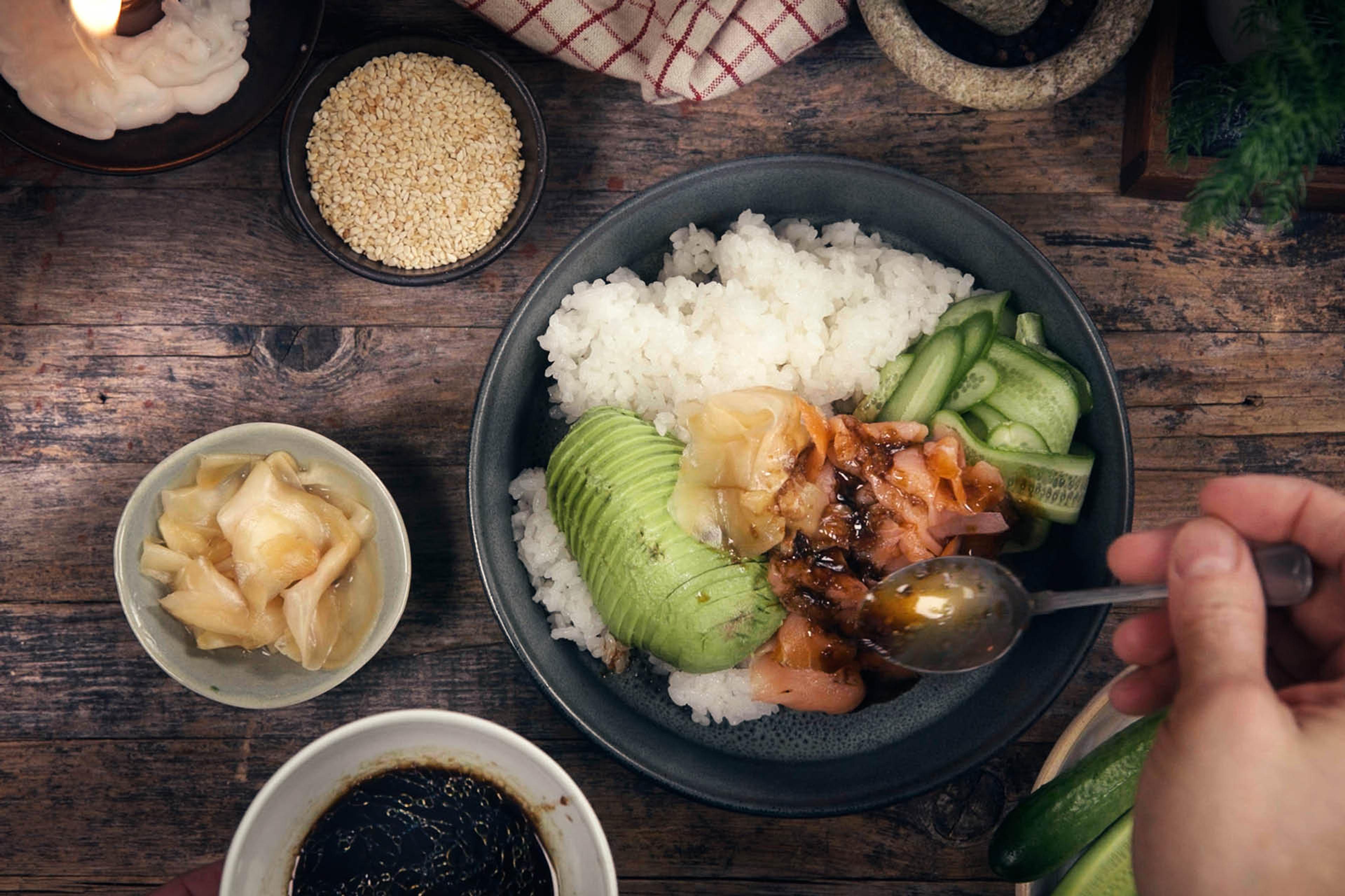 En bowl med kallrökt lax, avokado, ris, gurka, ingefära