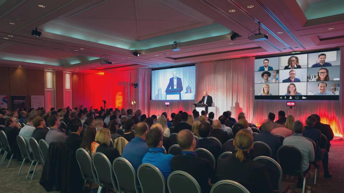 Hybrid event setup with livestream screen and in-person audience