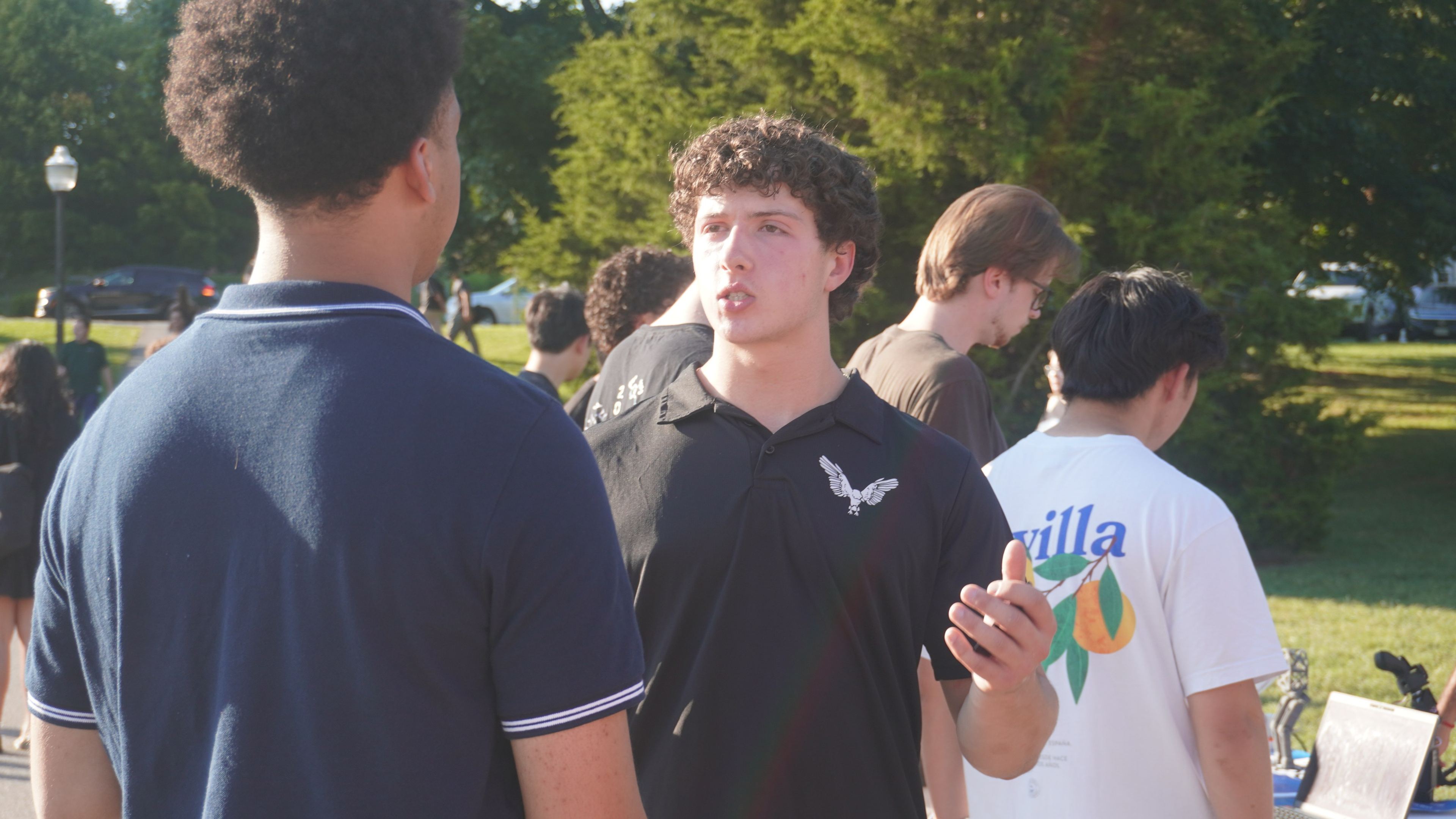 A member talking with a student outdoors