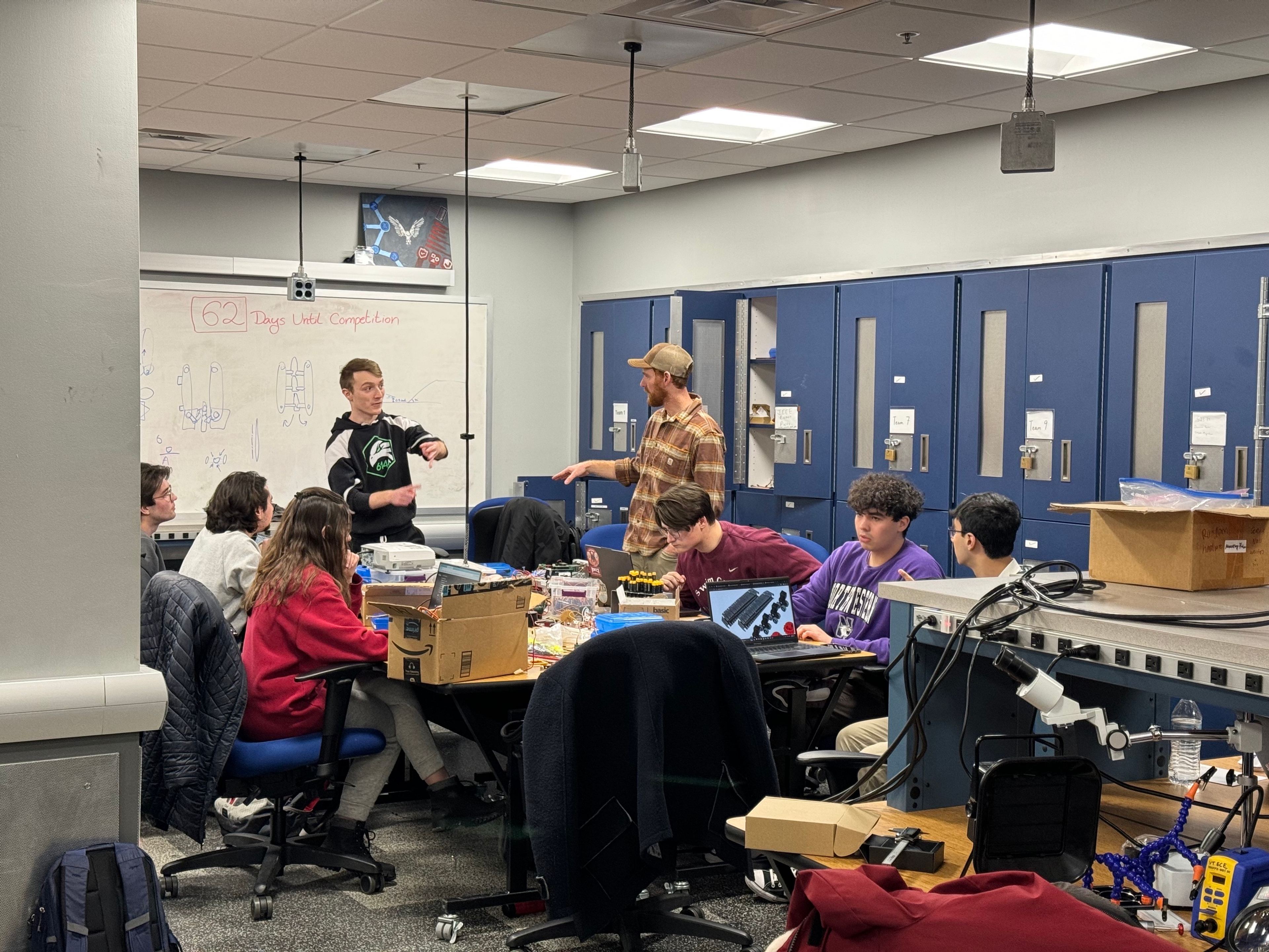 Members planning around the lab whiteboard, 62 days before a competition