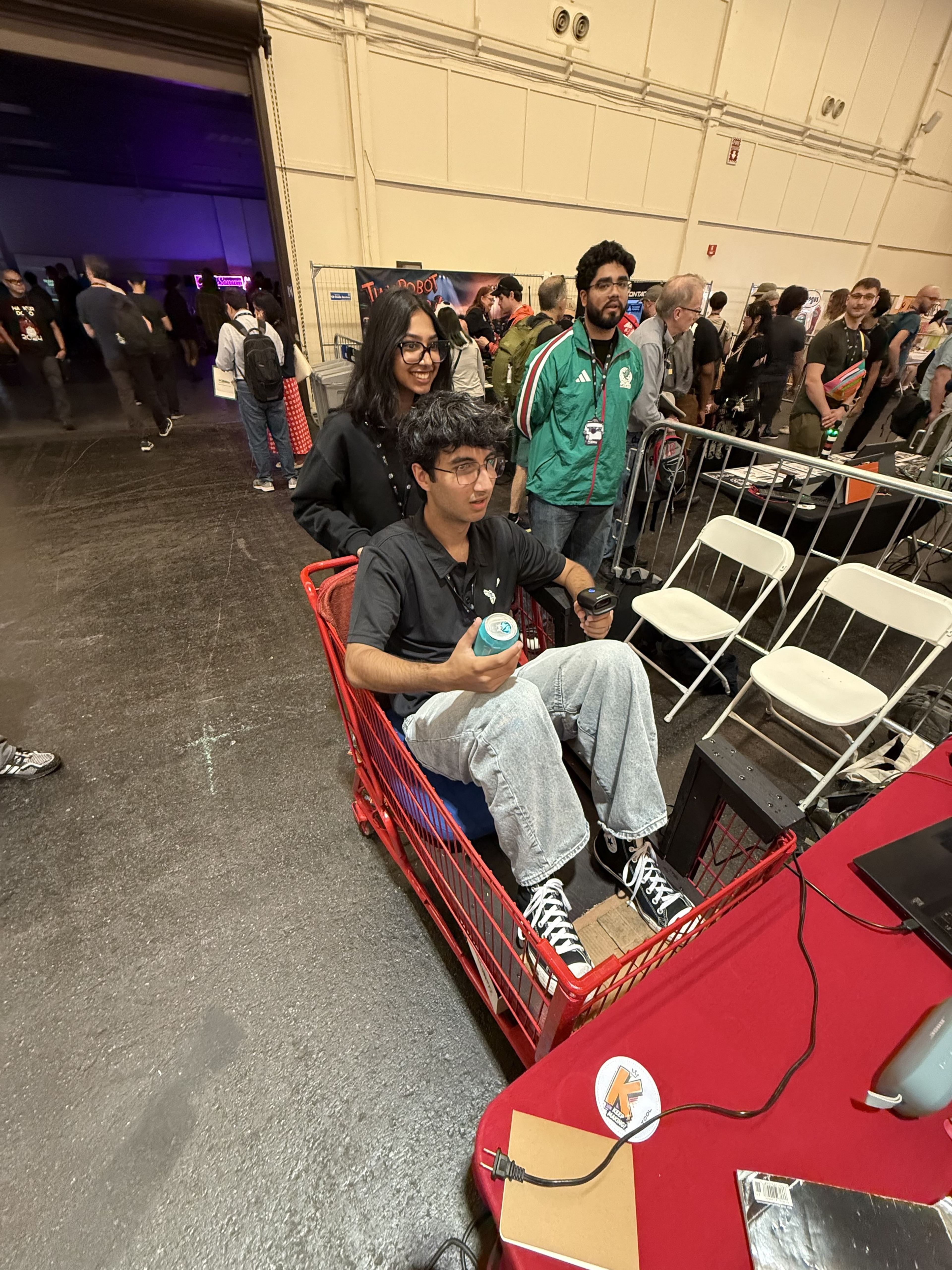 A member sitting in a red wagon in an exhibit hall