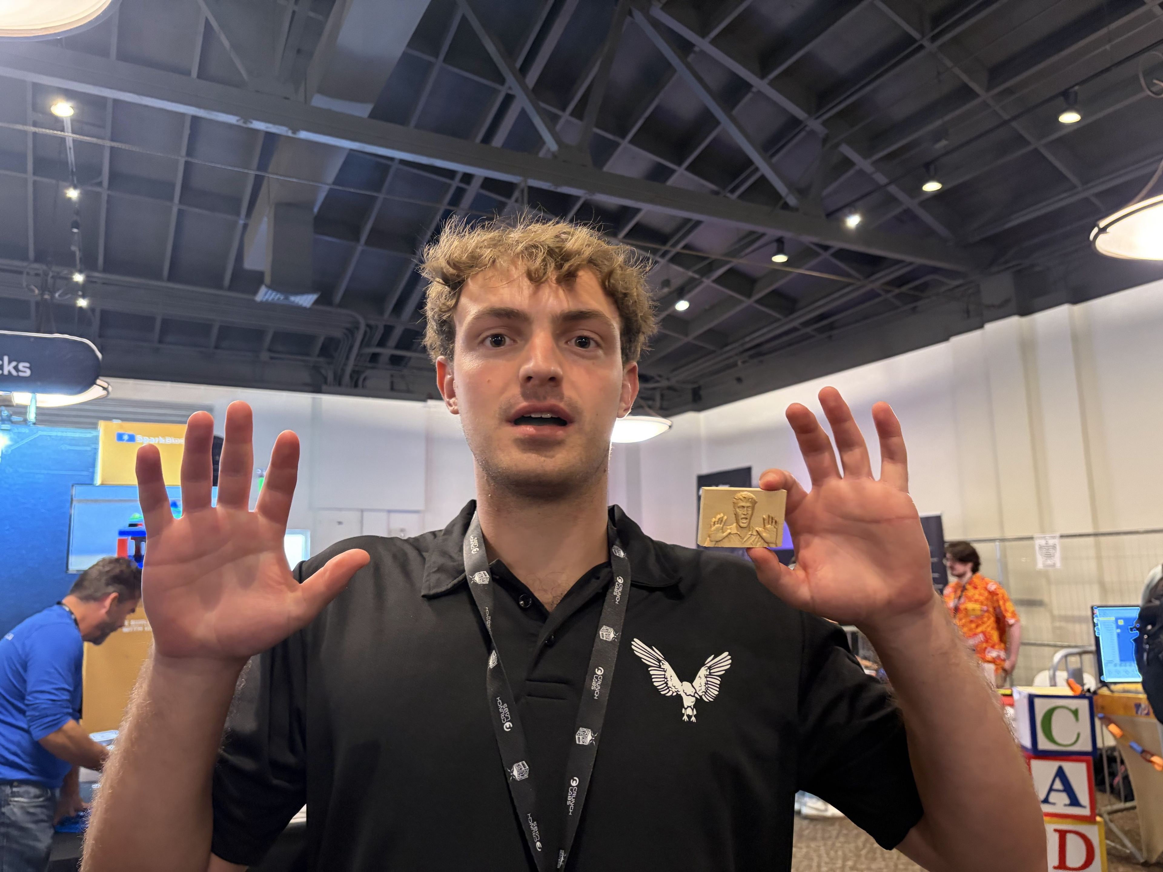 A member in a VT CRO polo waving at the camera in an exhibit hall