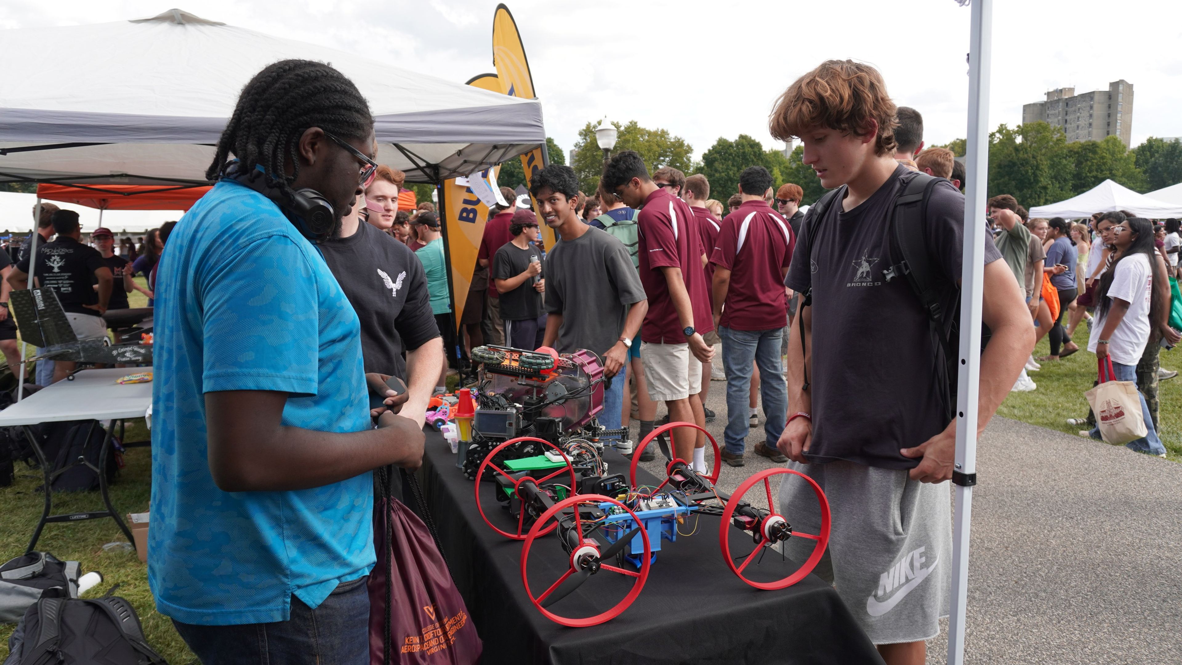 Students looking at robots at the VT CRO tent