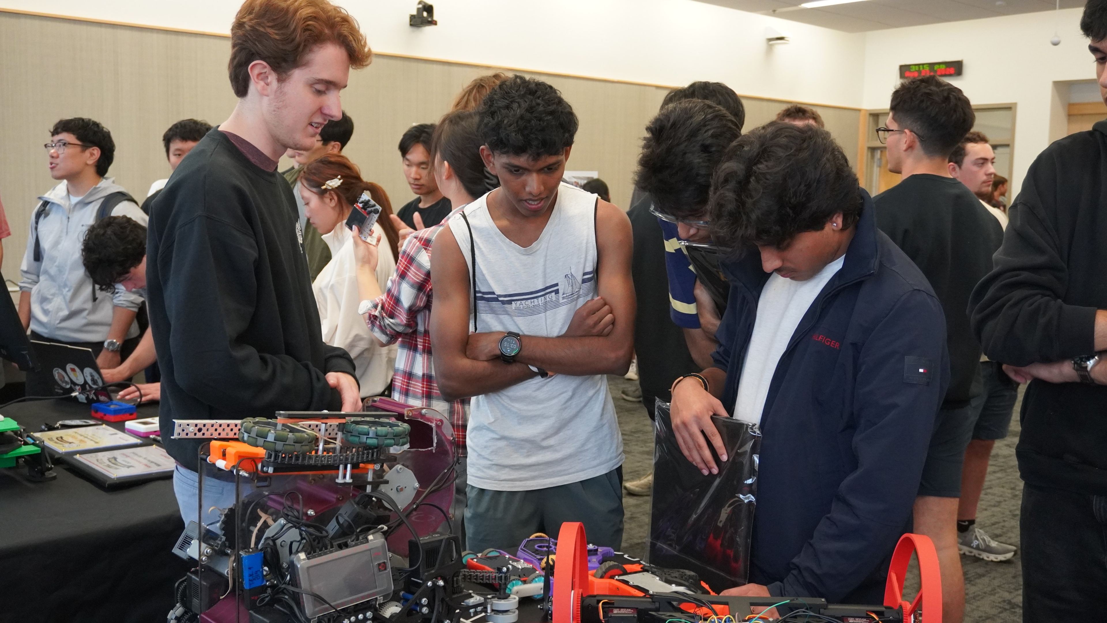 Students looking at VT CRO robots on the display table