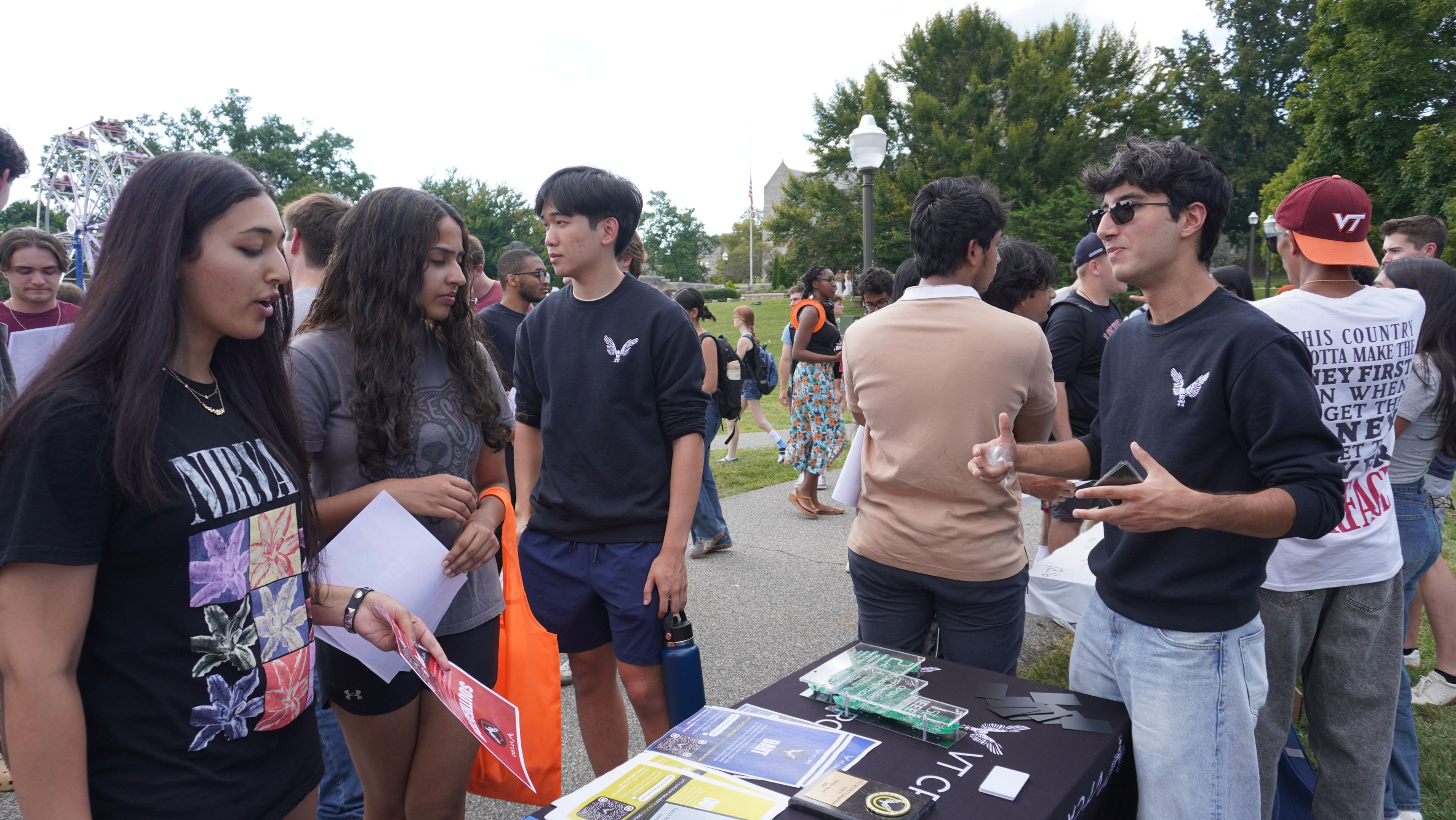 Members at the VT CRO table talking with students at an outdoor fair