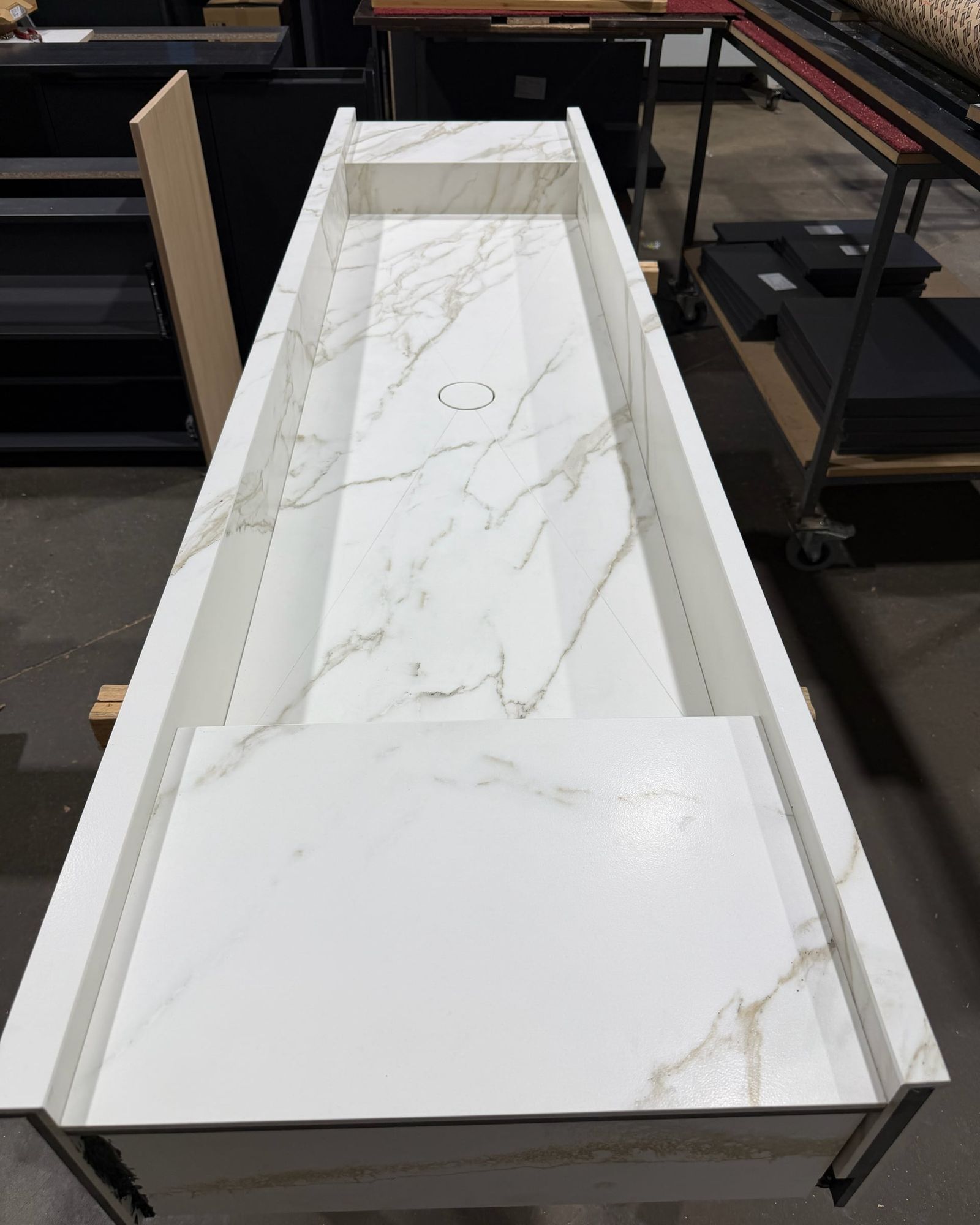 Wastafel in marmerlook van bovenaf in de werkplaats, met schuine bodem, afvoer en verhoogd plateau