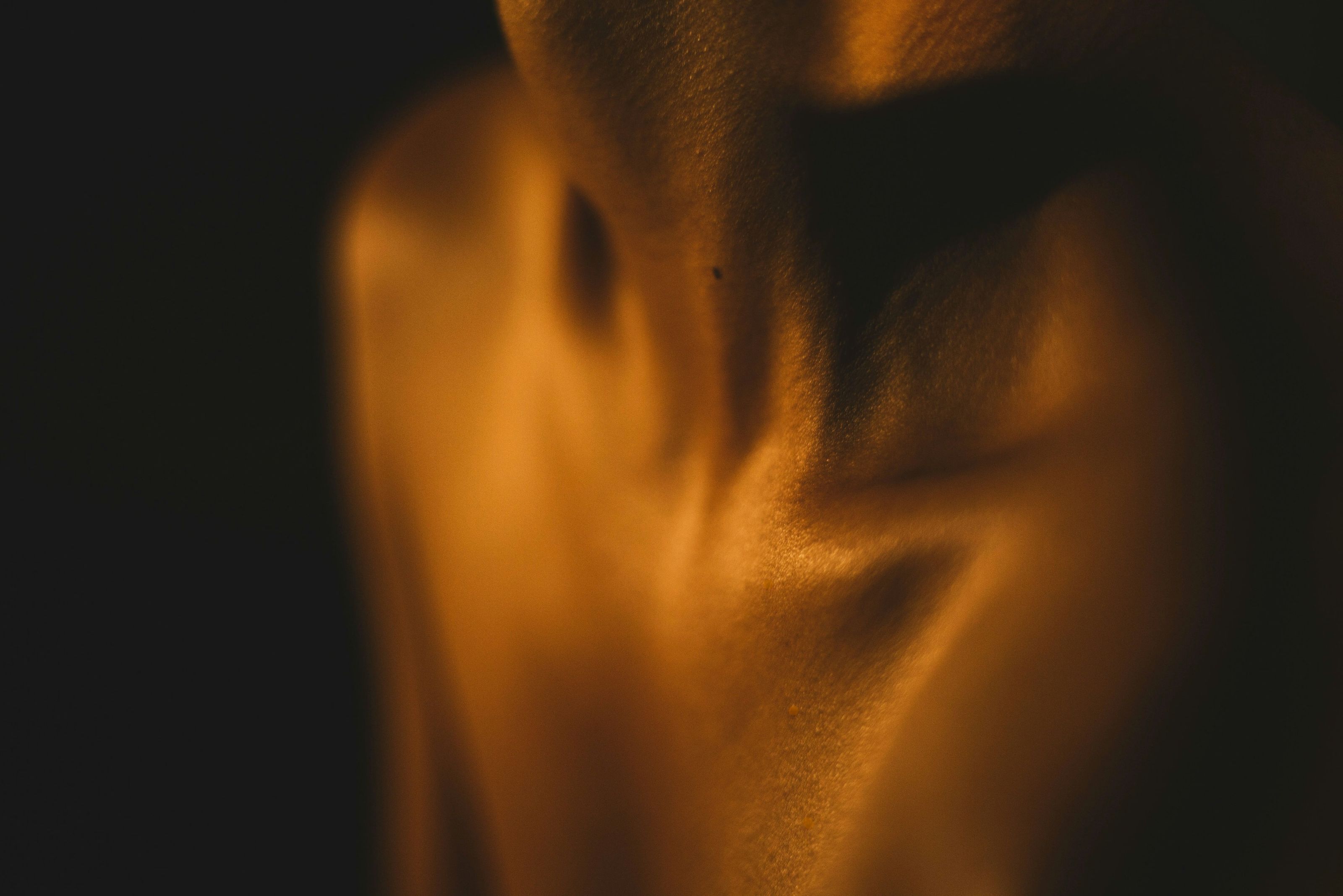 Soft golden light across a woman's neck and collarbone