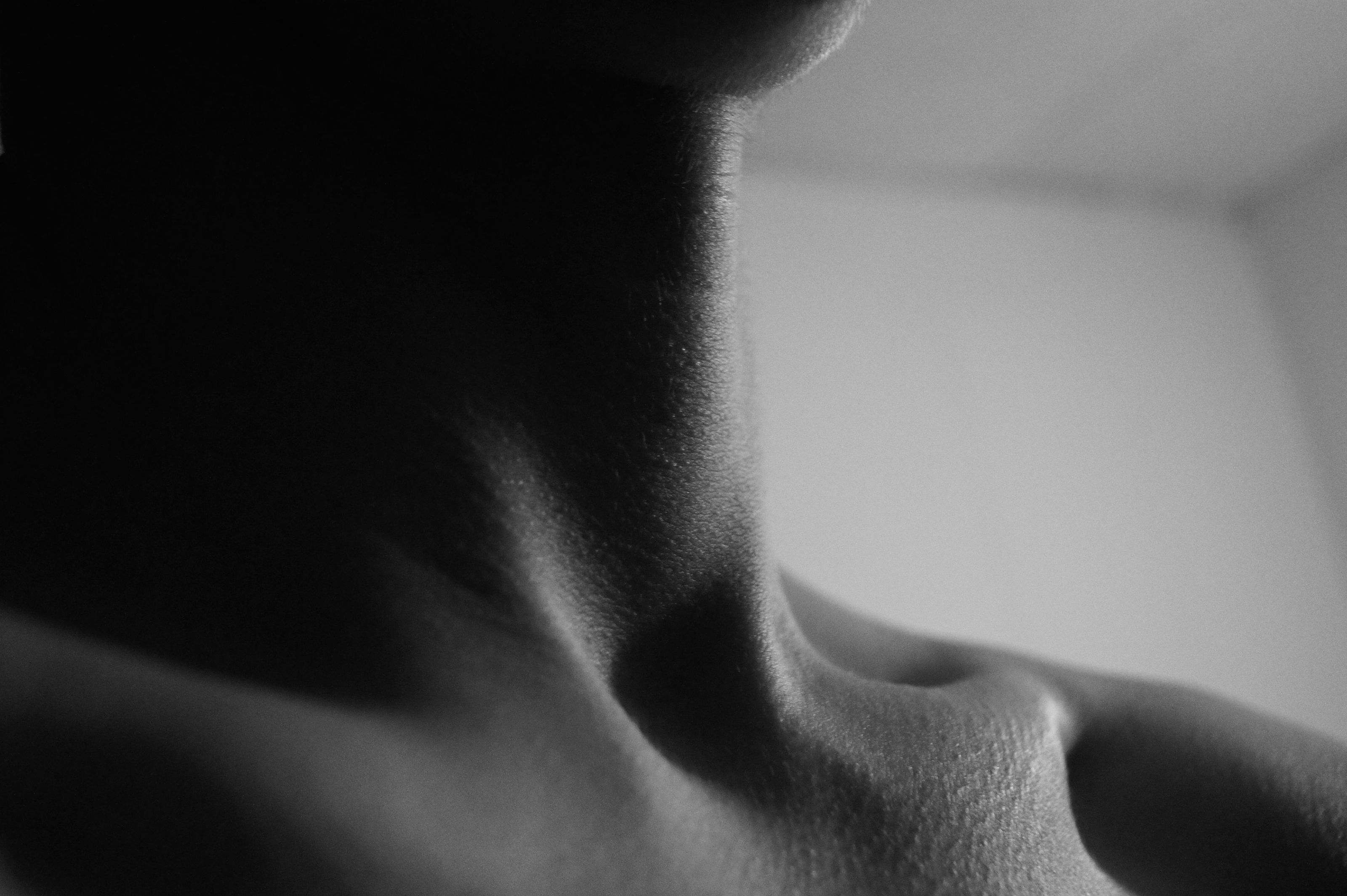 Close view of a woman's neck and shoulder in soft black and white
