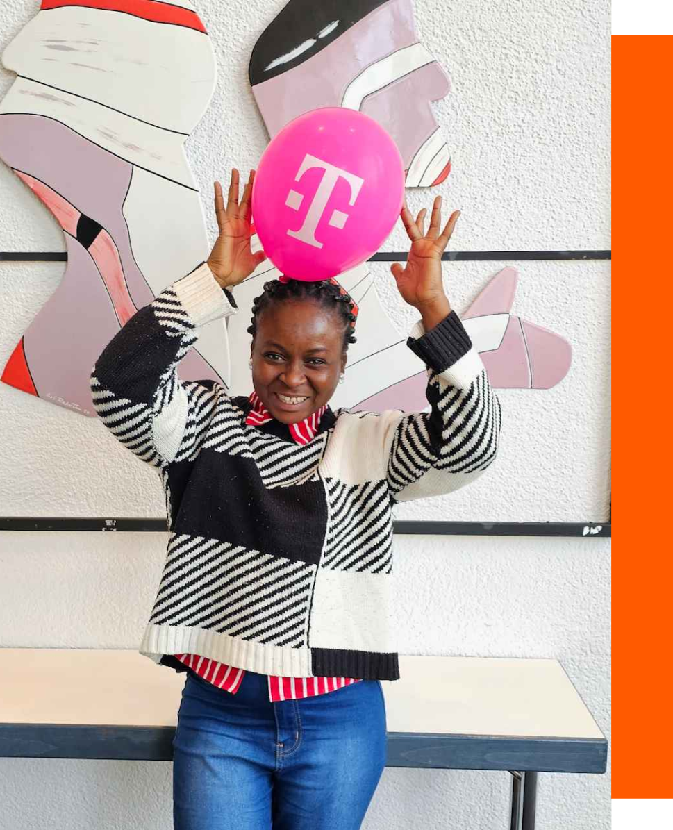 A female software developer smiling while playing with a telecom-pumped balloon slightly above her head.