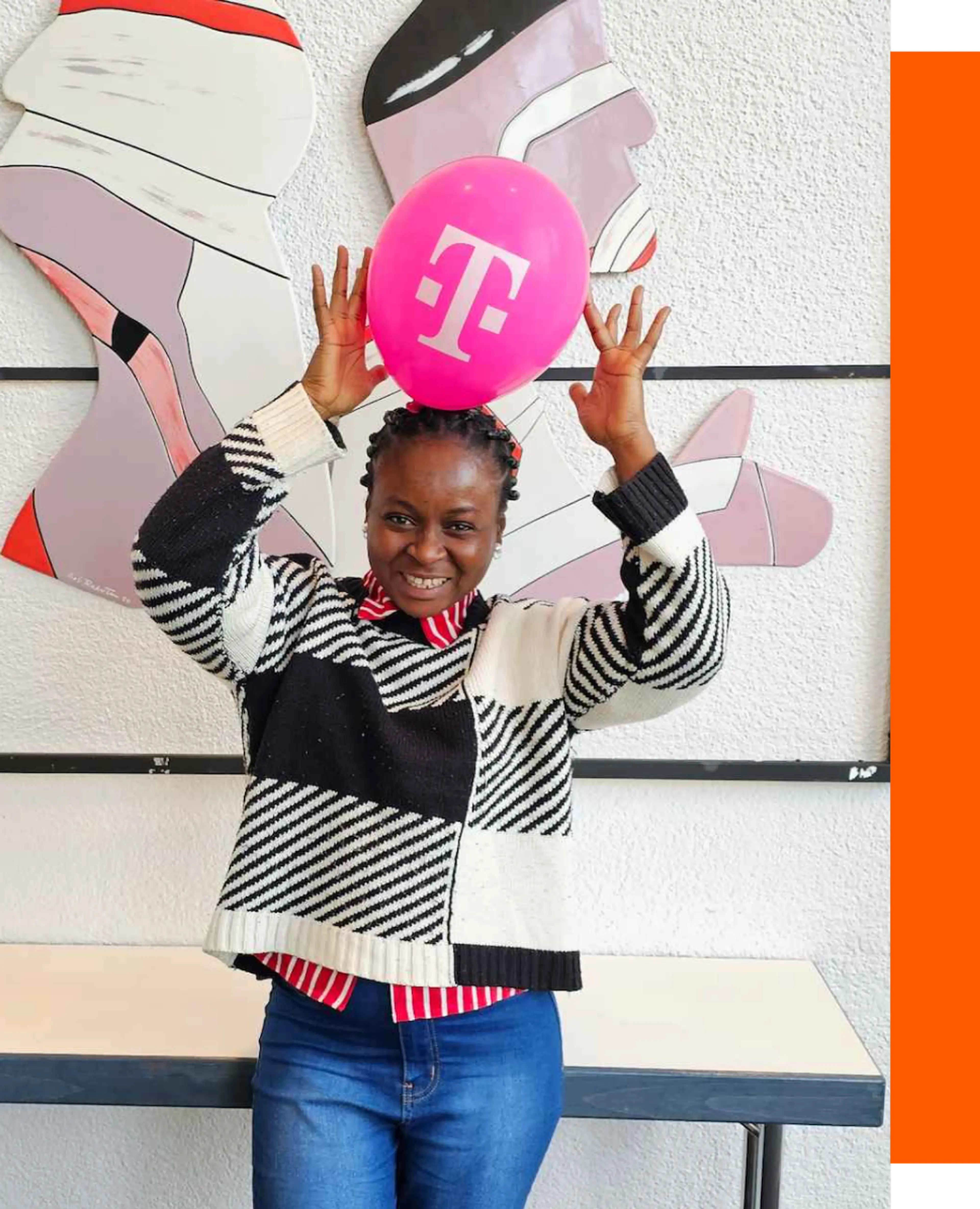 A female software developer smiling while playing with a telecom-pumped balloon slightly above her head.