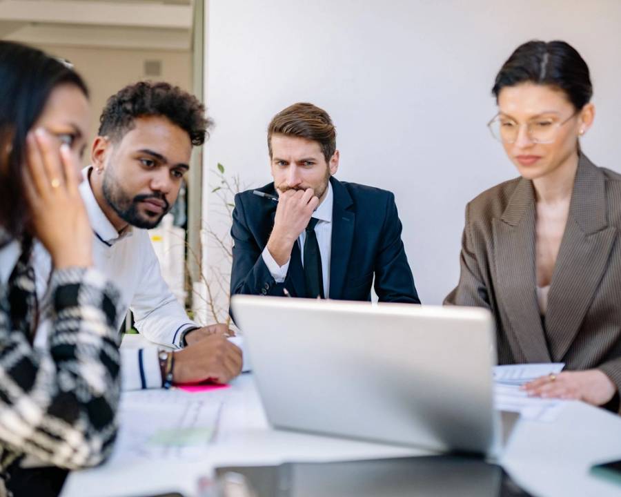 A team in an office looking at a laptop together
