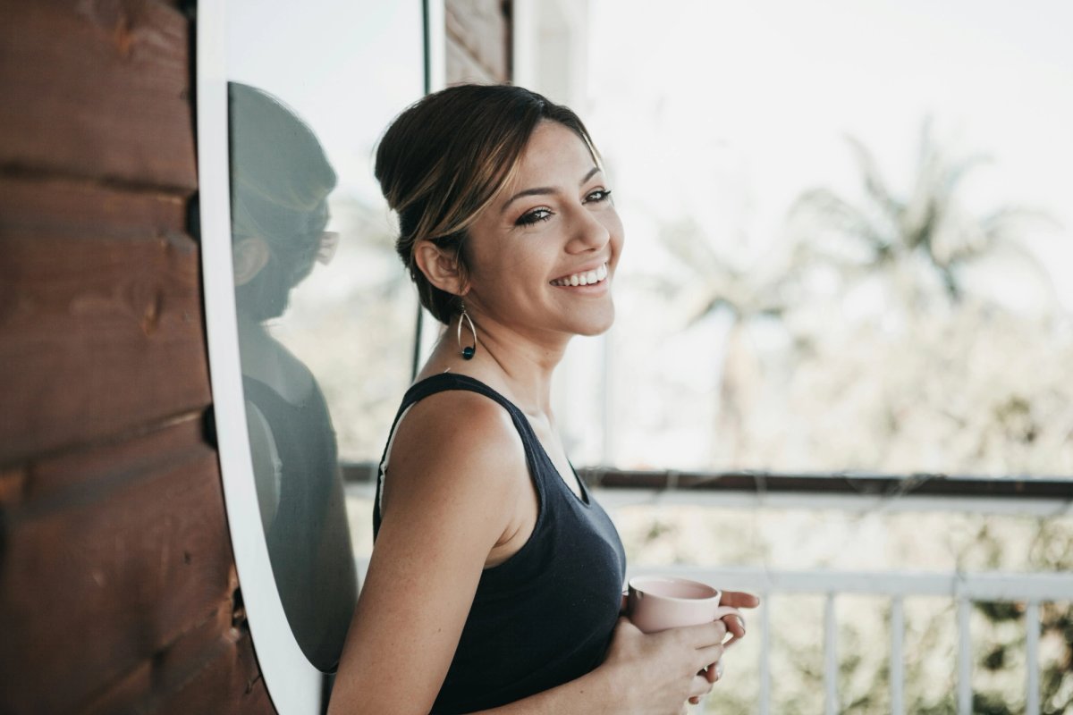 a photo of smiling woman holding a coffee mug