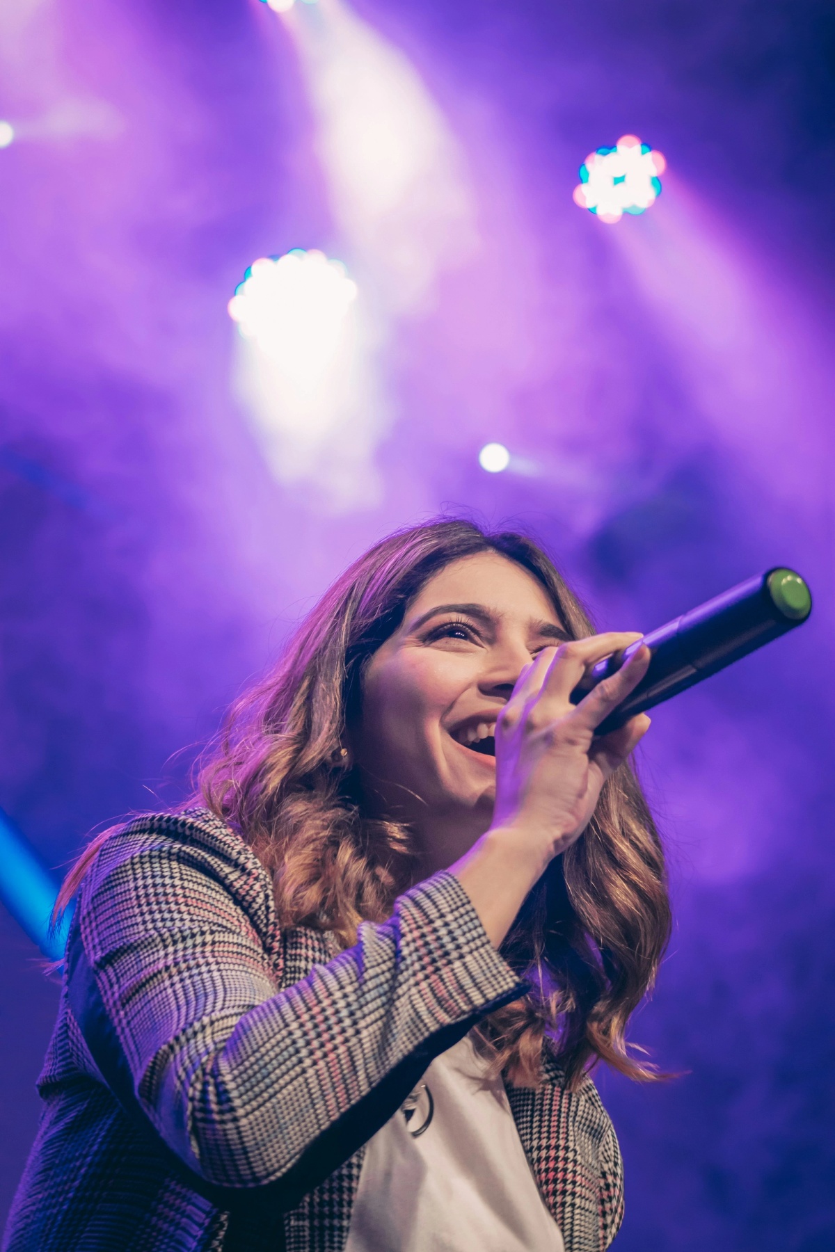 a woman singing on the stage with mic