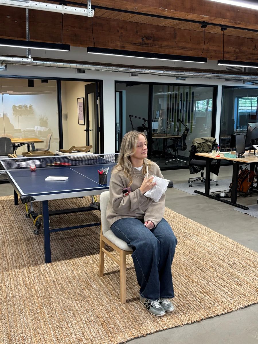 Sproutbox teammate sitting in a chair in the middle of the office during a team game