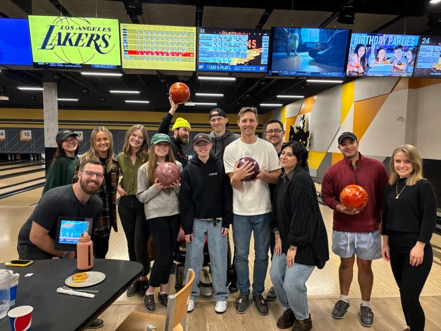 Big Sproutbox team group photo at a bowling alley, a few teammates holding up bowling balls