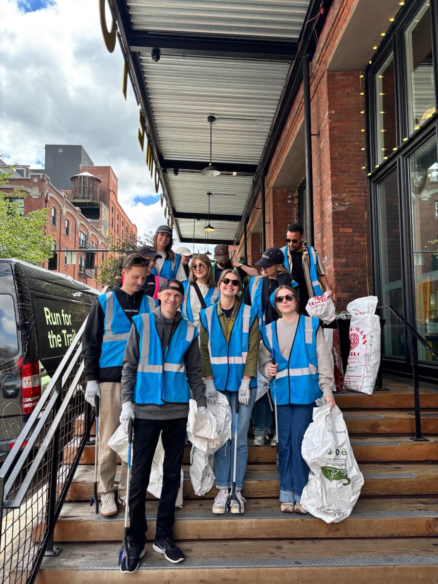Sproutbox team in safety vests with trash bags on a downtown sidewalk during a cleanup day
