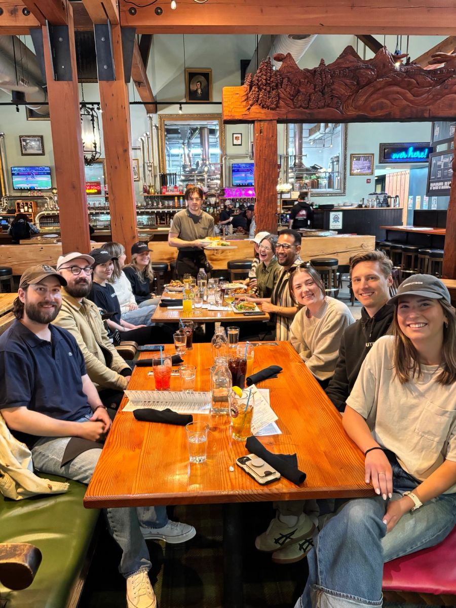 Sproutbox team sharing drinks around a long table at a restaurant