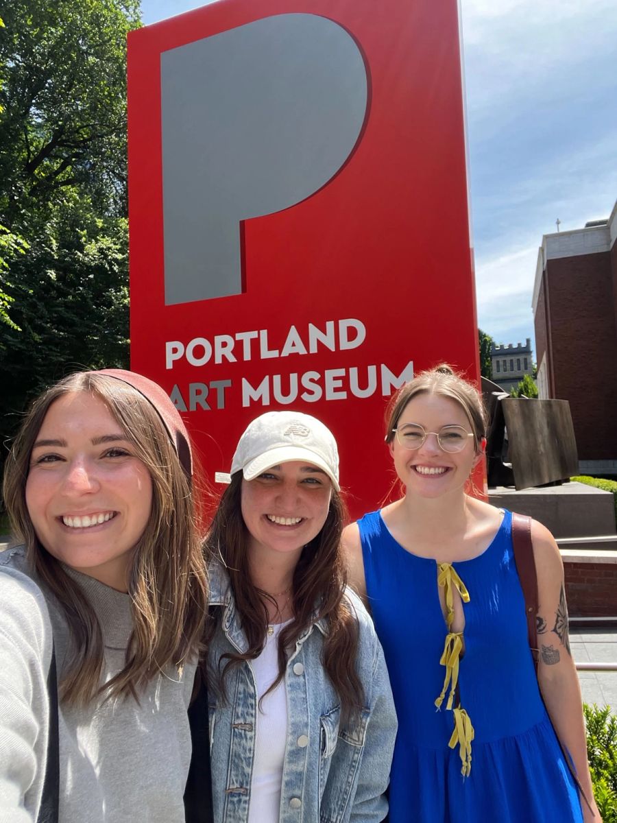 Three Sproutbox teammates smiling in front of the Portland Art Museum sign
