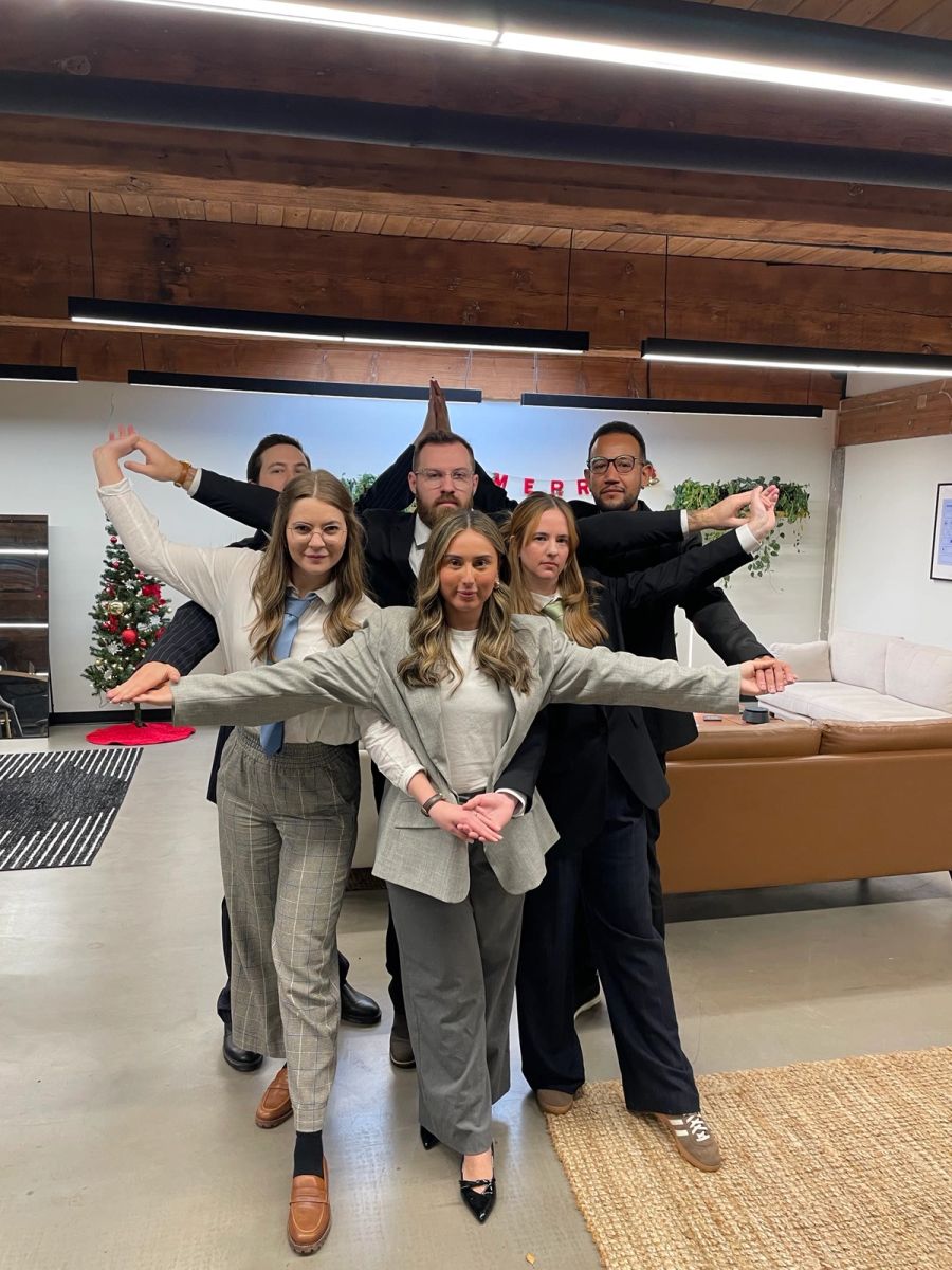 Sproutbox team striking a dramatic group pose next to the office Christmas tree