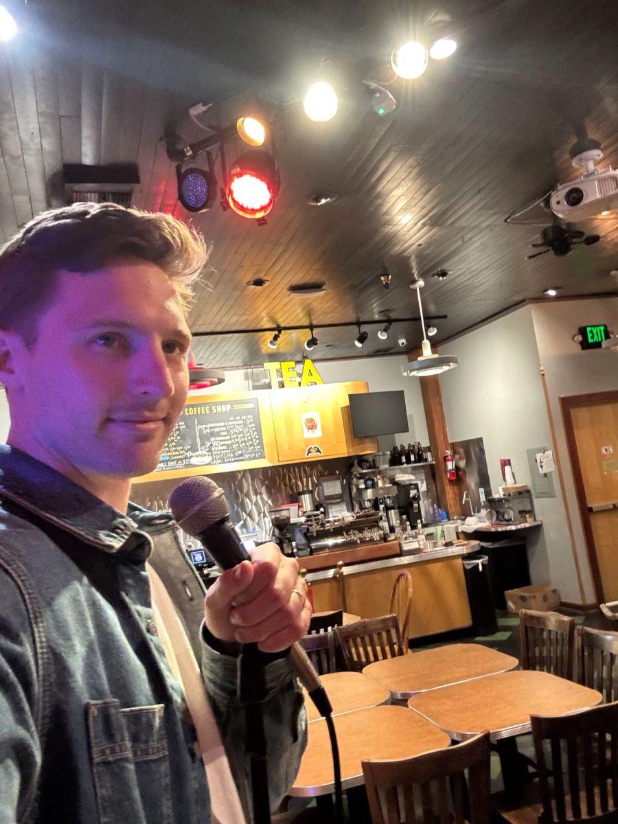 Sproutbox teammate holding a microphone in a selfie at a cafe