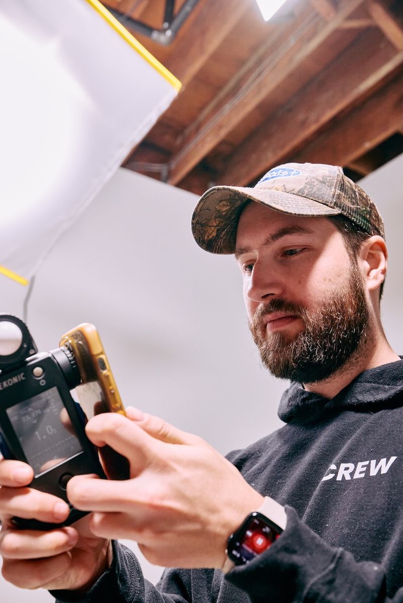 Photographer checking a light meter in the Sproutbox studio