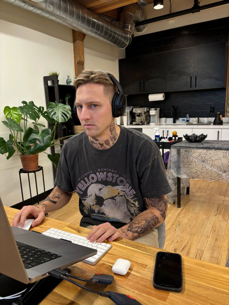 Sproutbox teammate in headphones focused at a laptop in the office kitchen area