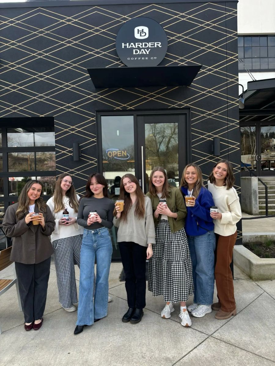 Seven Sproutbox teammates holding coffees outside Harder Day Coffee Co.