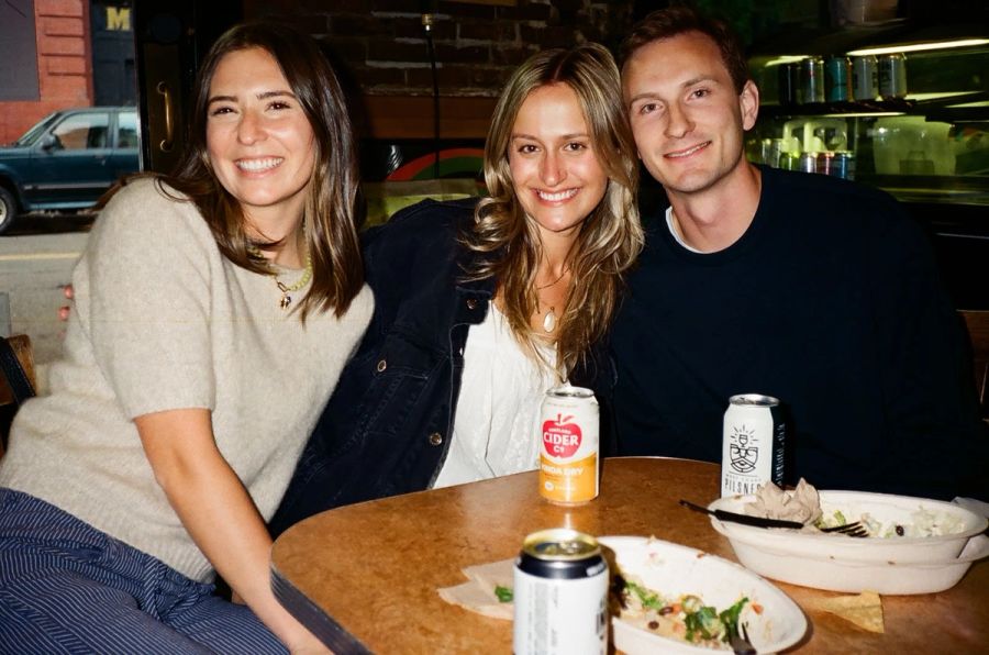 Three Sproutbox teammates posing together at a bar table