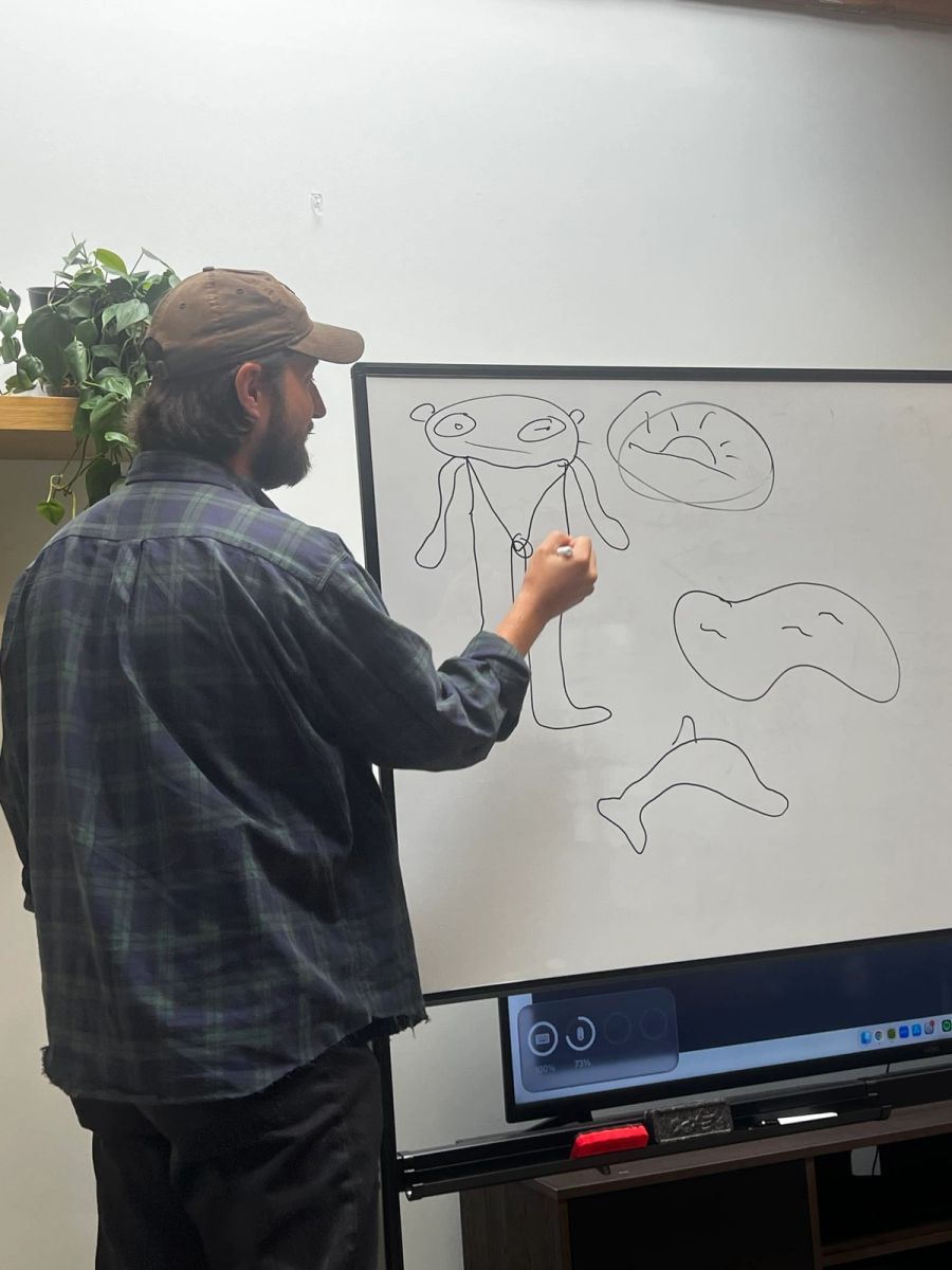 Sproutbox teammate drawing silly doodles on the office whiteboard