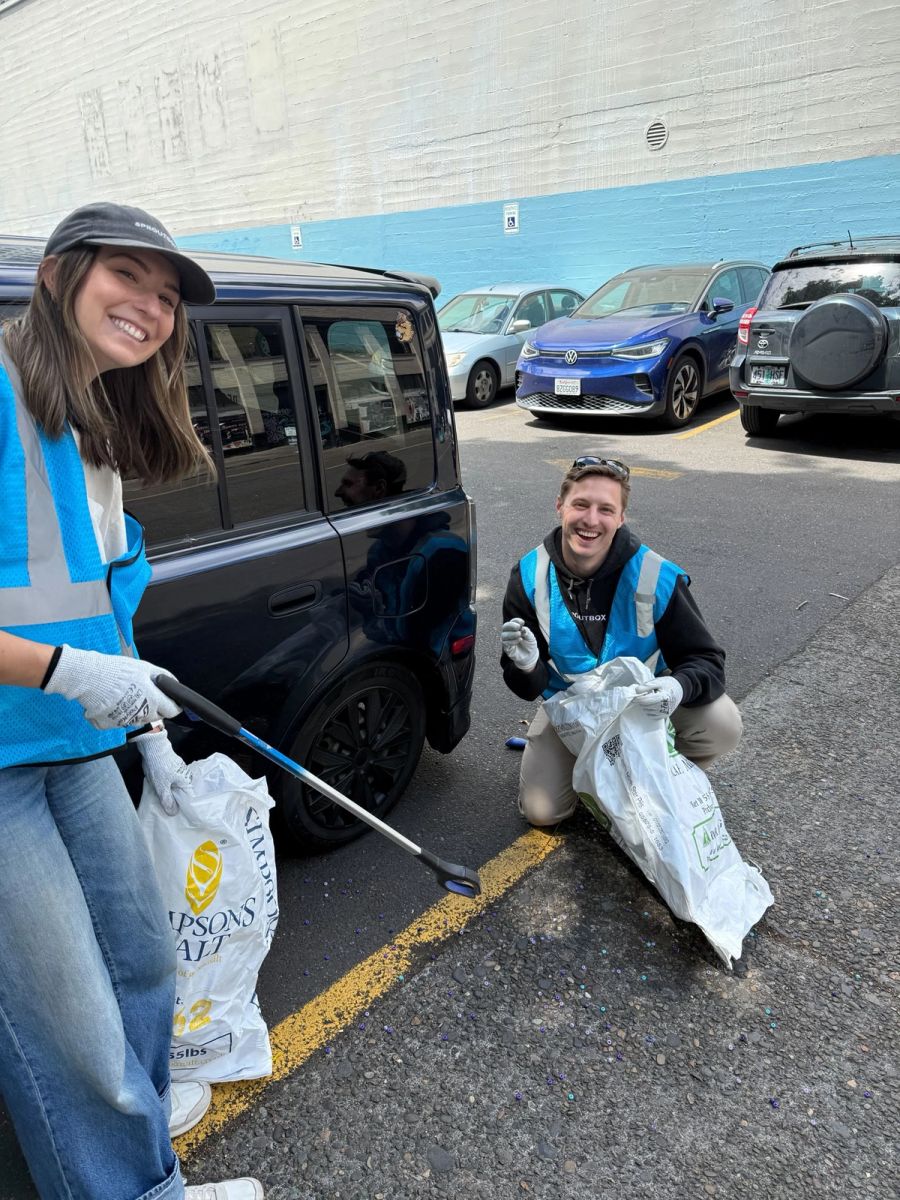 Two Sproutbox teammates picking up litter in a parking lot