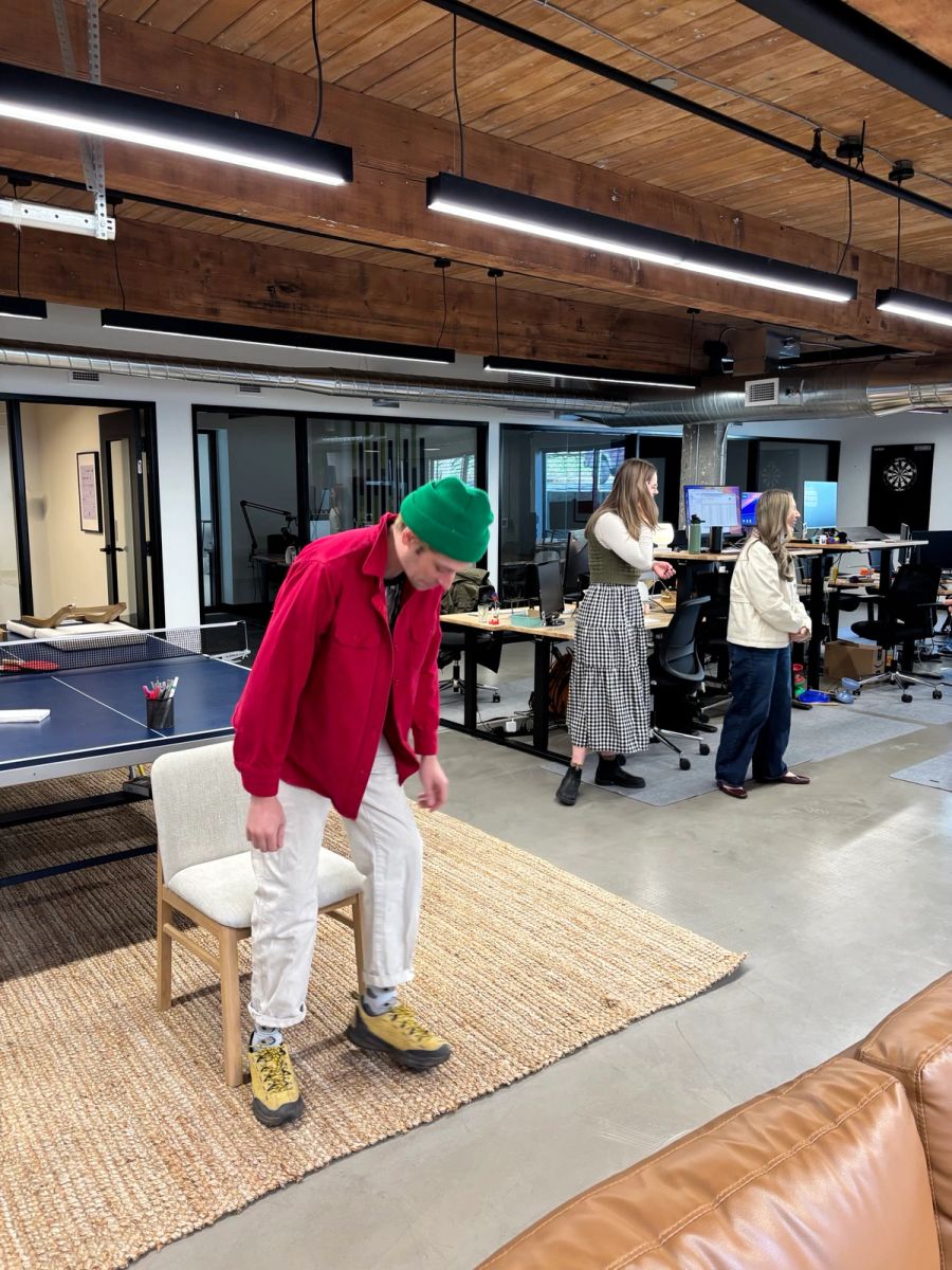 Sproutbox teammate in a green beanie mid-game in the office