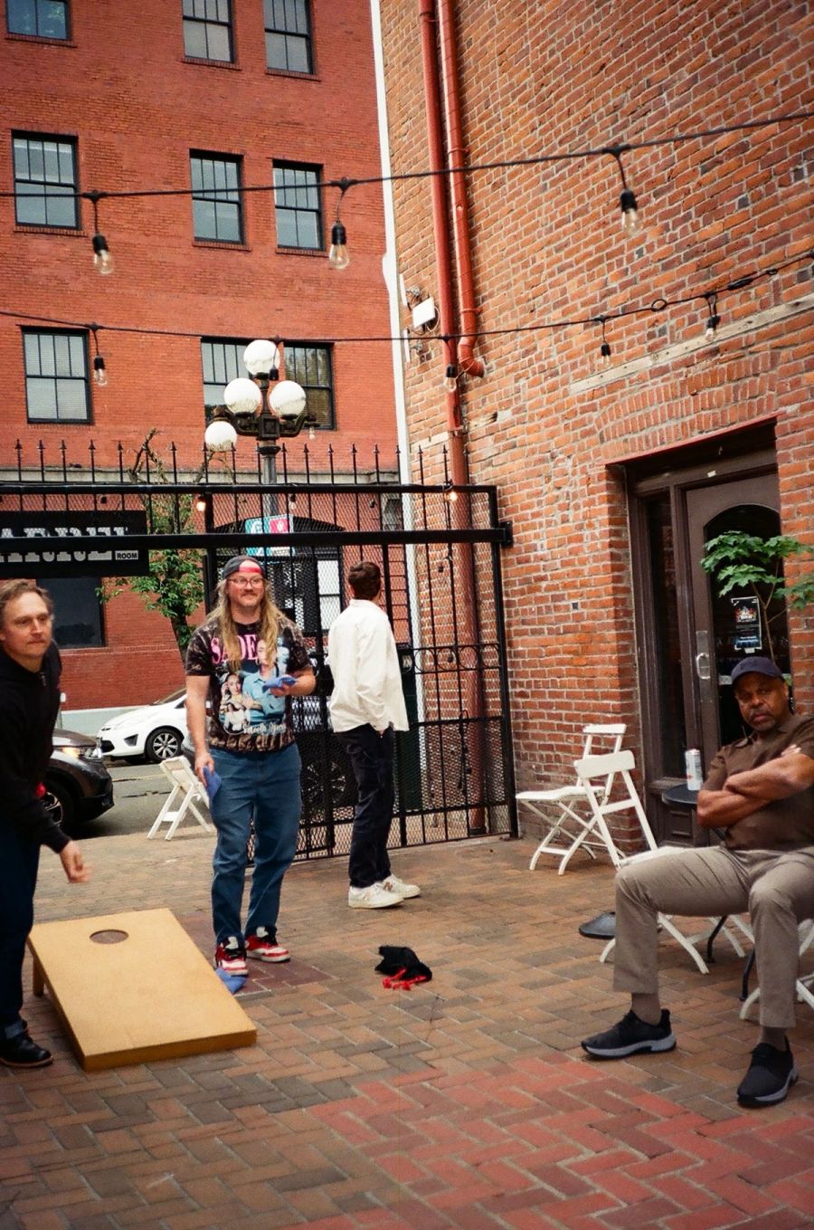 Sproutbox team playing cornhole in a brick courtyard